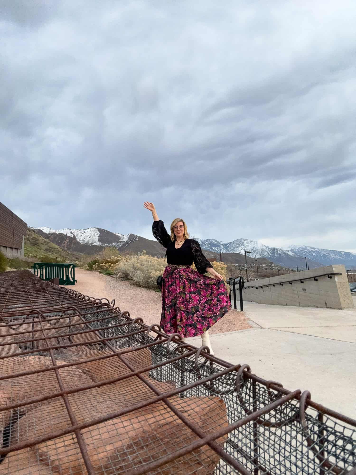 Jenna Passaro travel blogger posing with mountain range at Natural History Museum of Utah 