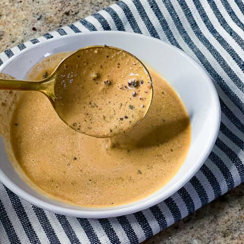 Close-up of creamy peppercorn steak sauce in a serving dish
