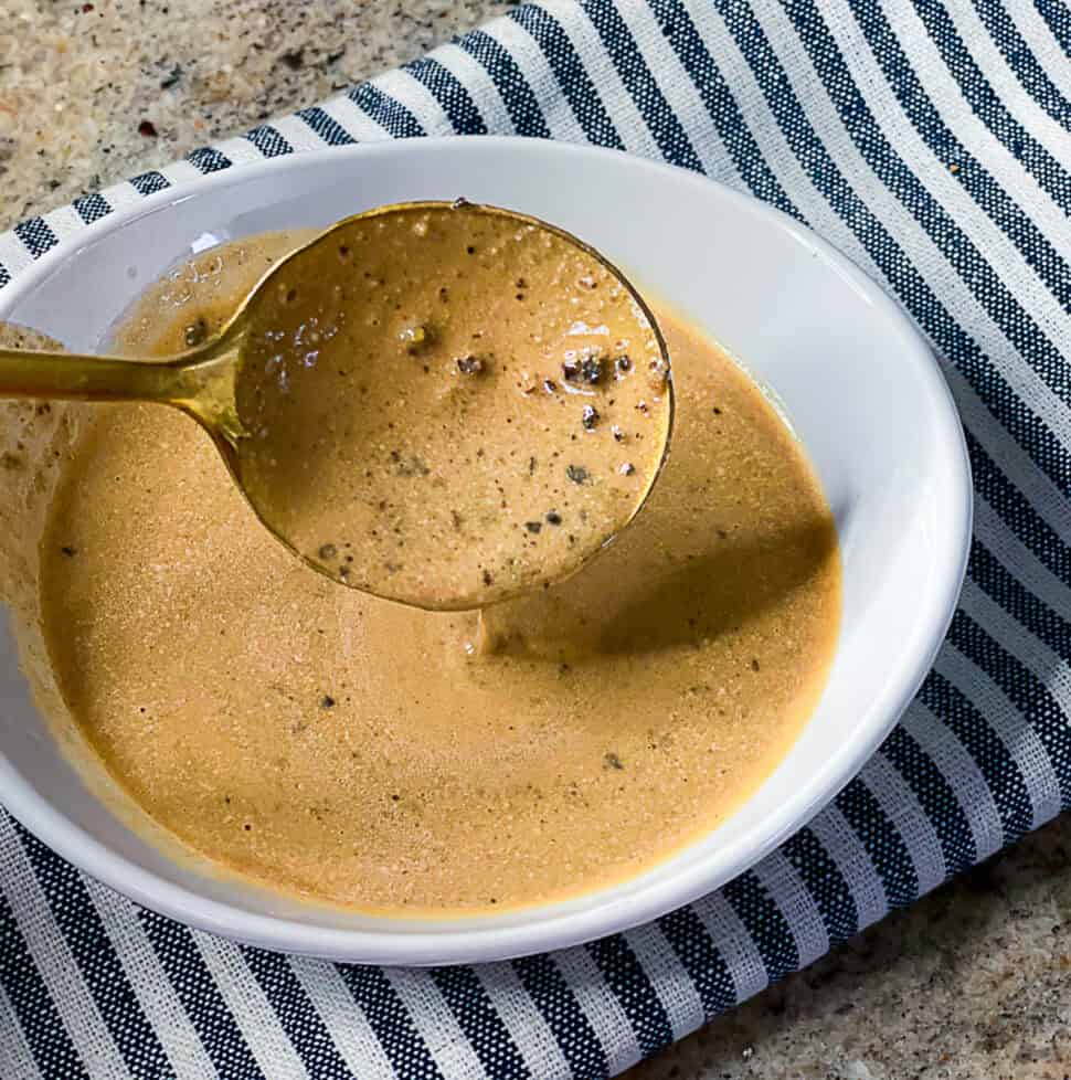 Close-up of creamy peppercorn steak sauce in a serving dish
