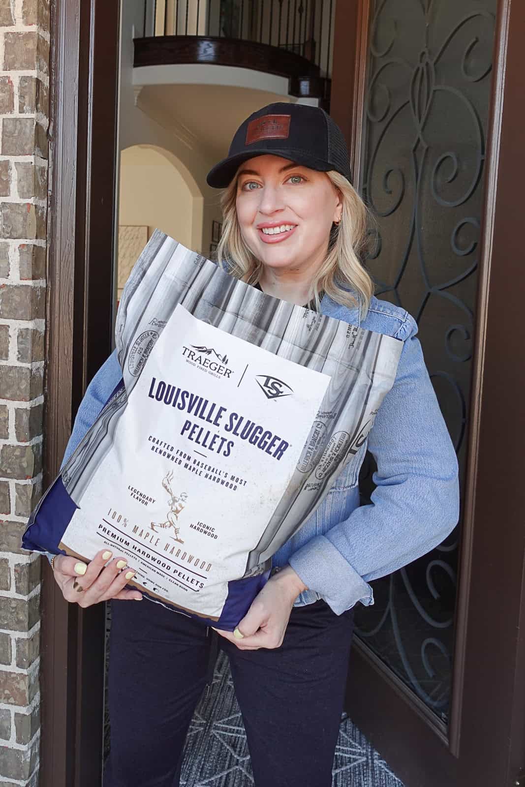 Jenna Passaro food blogger ambassador holding Traeger Louisville Slugger maple pellets