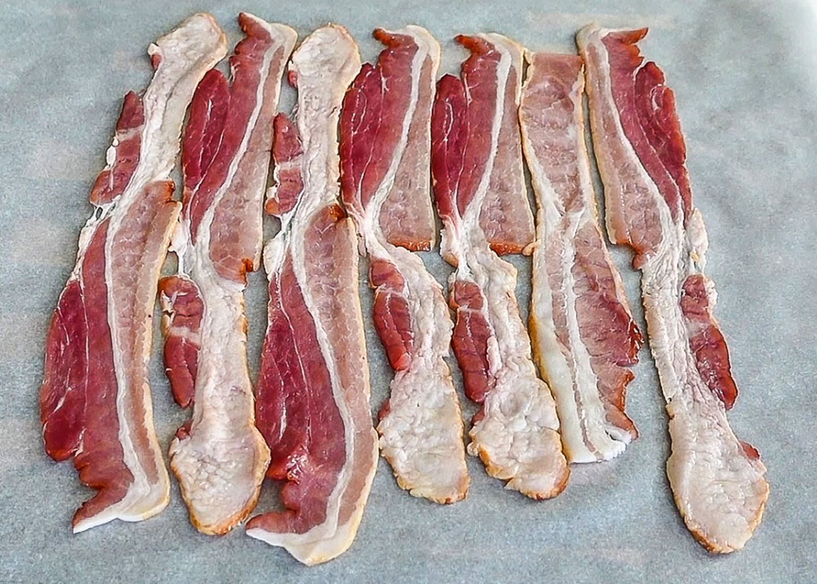 Bacon laid flat on parchment paper