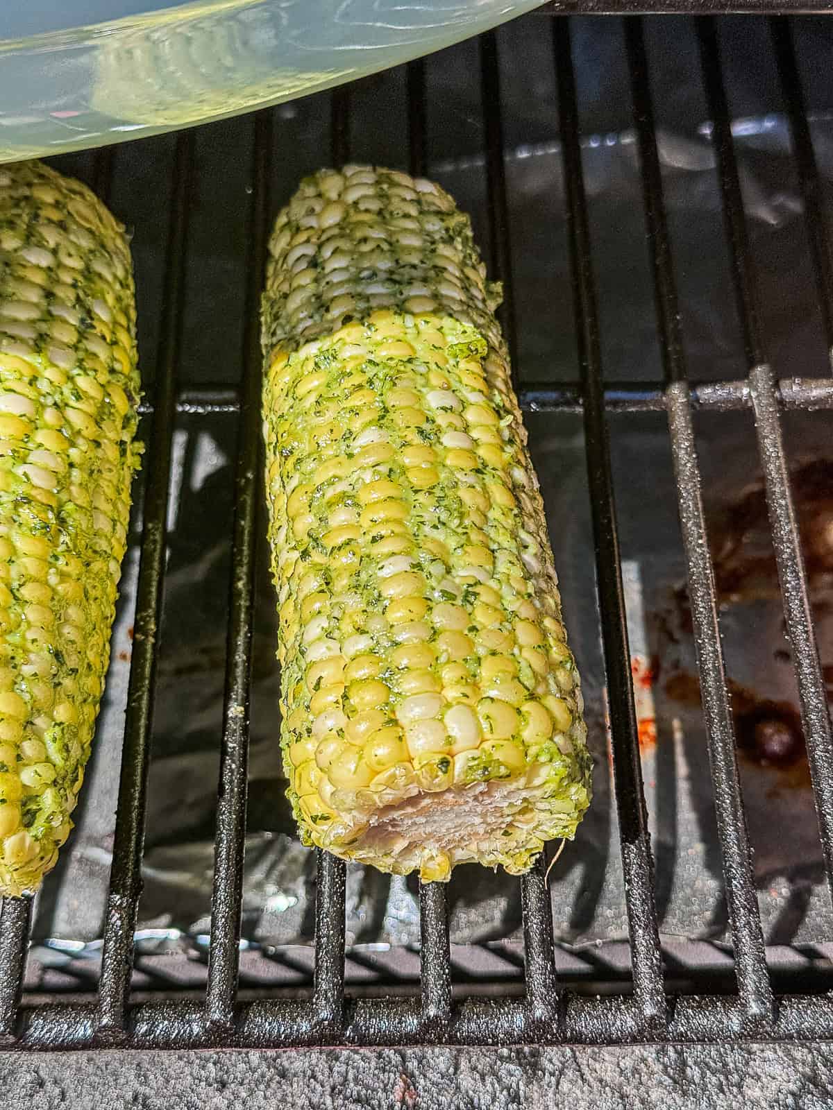Closeup of Smoking Corn on the cob on the Traeger with pesto