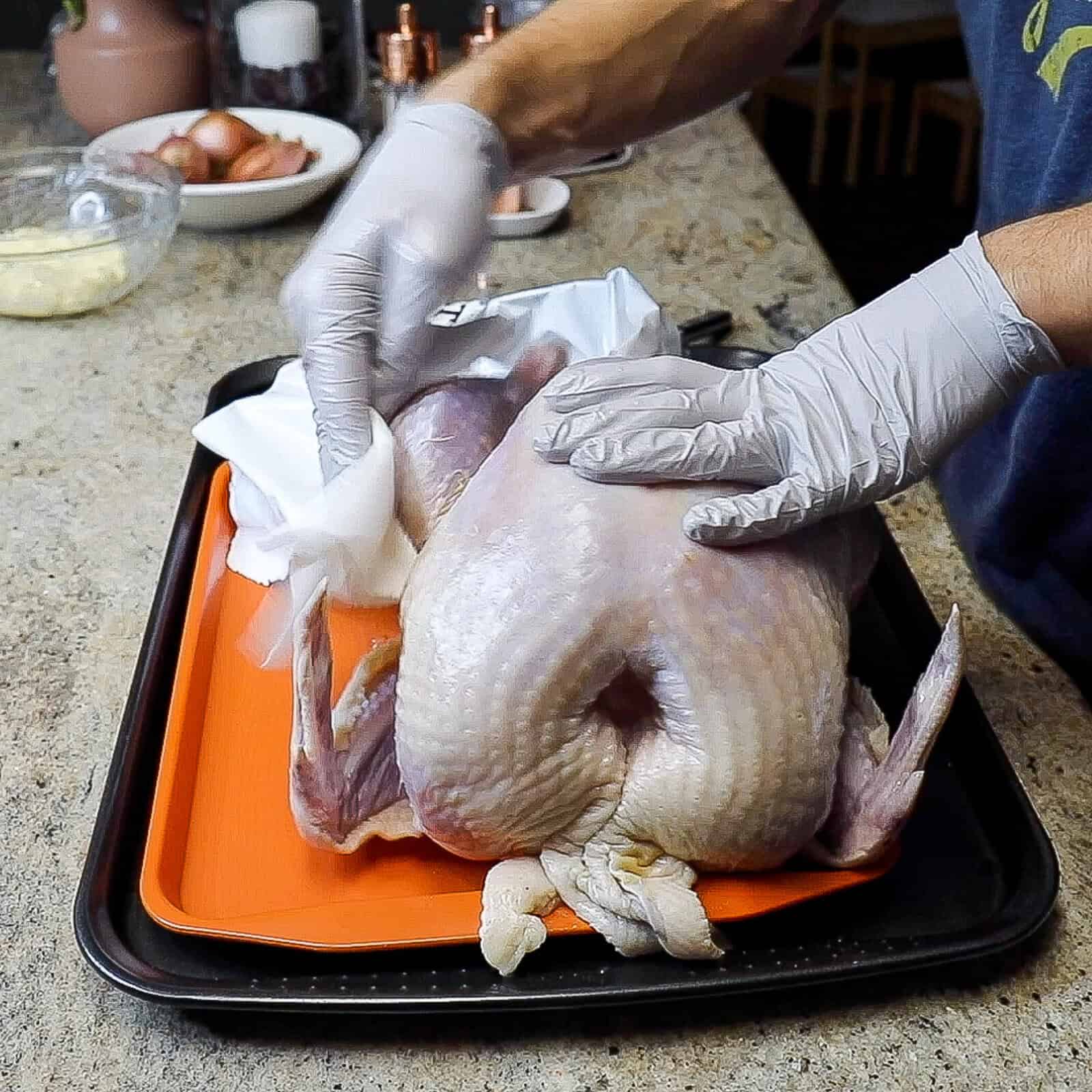 Preparing a raw whole turkey by removing packaging and patting dry