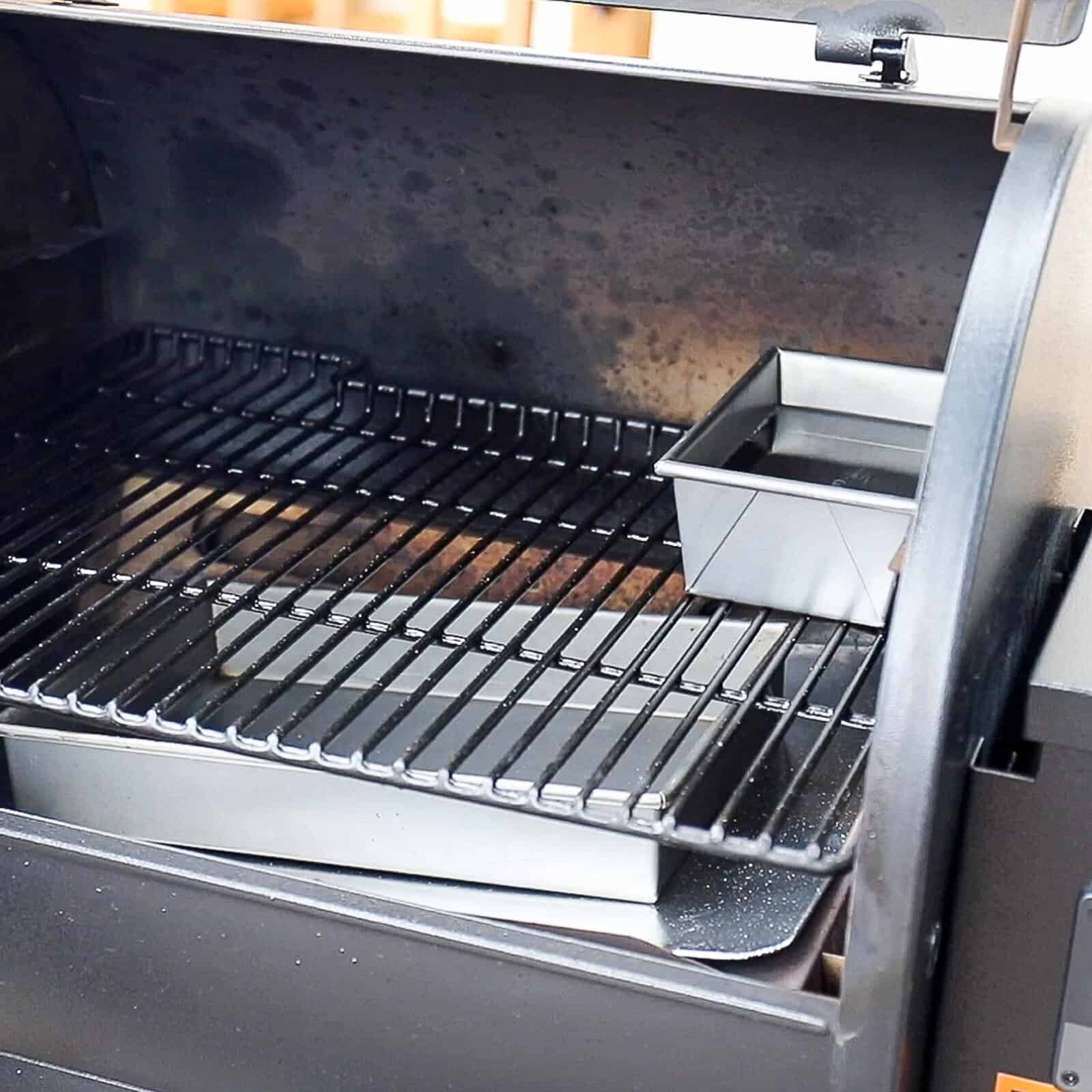 Preheating a Traeger smoker with water pan and drip pan in place