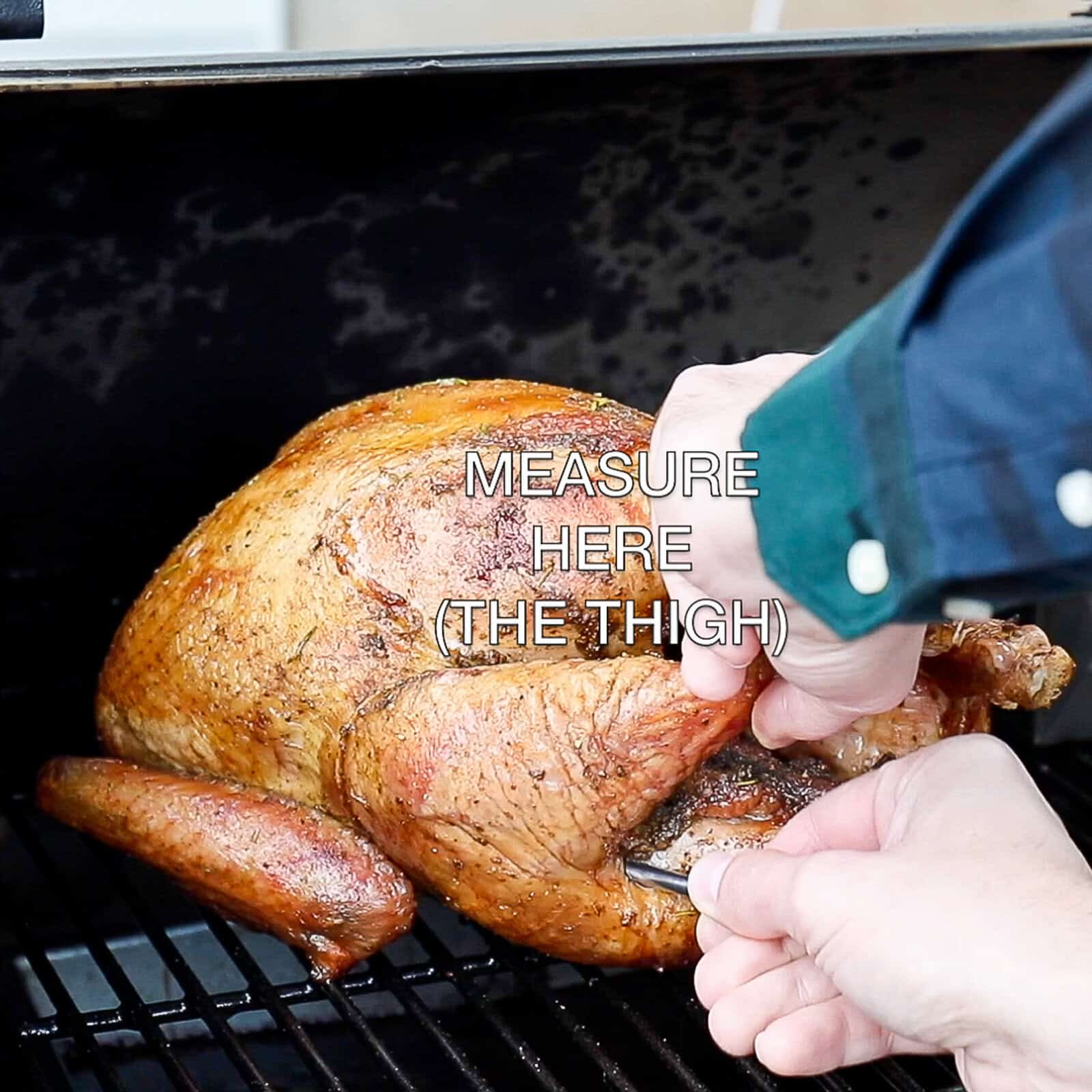 Checking the internal temperature of a smoked whole turkey with a meat thermometer