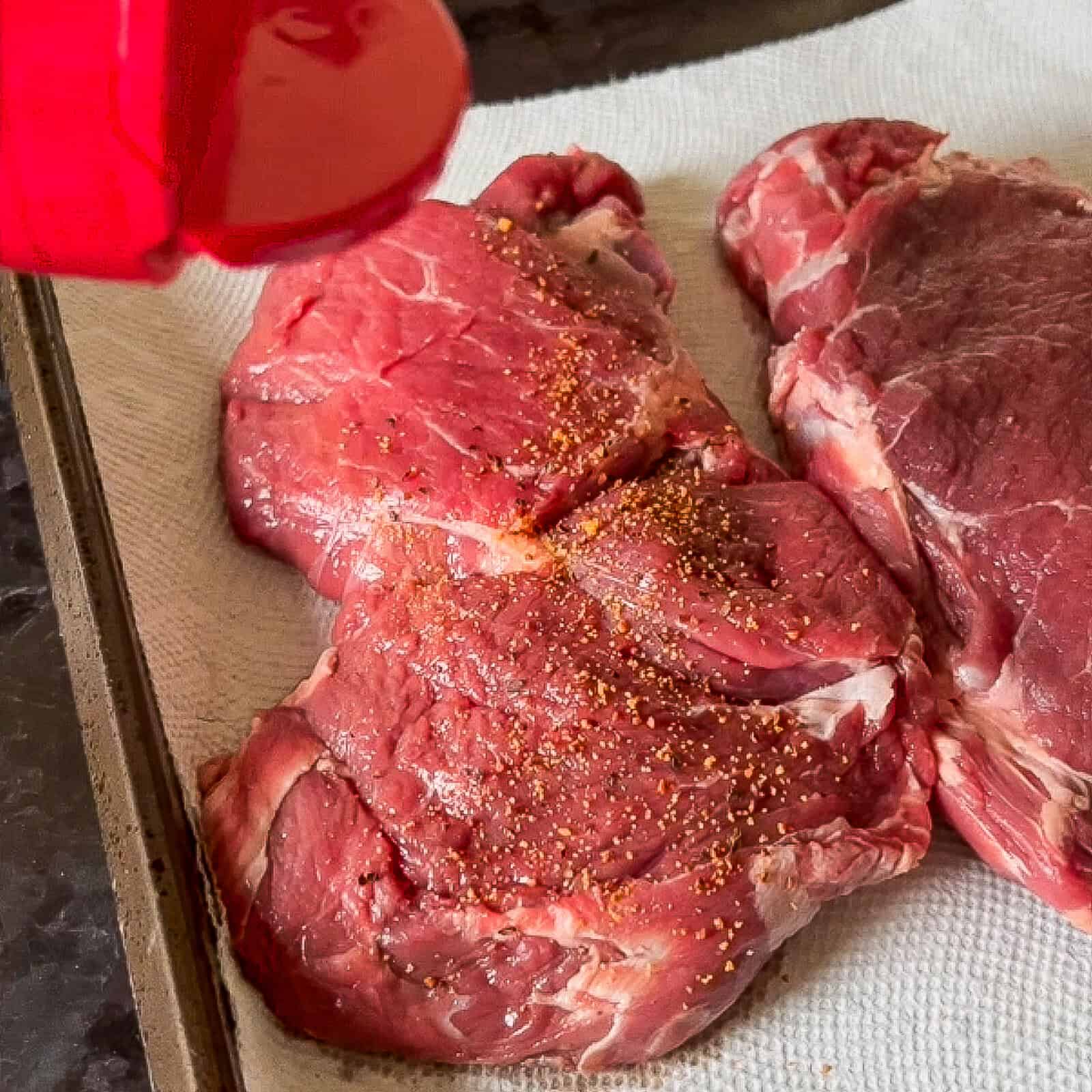 Grilling ribeye steaks over direct flame on grill