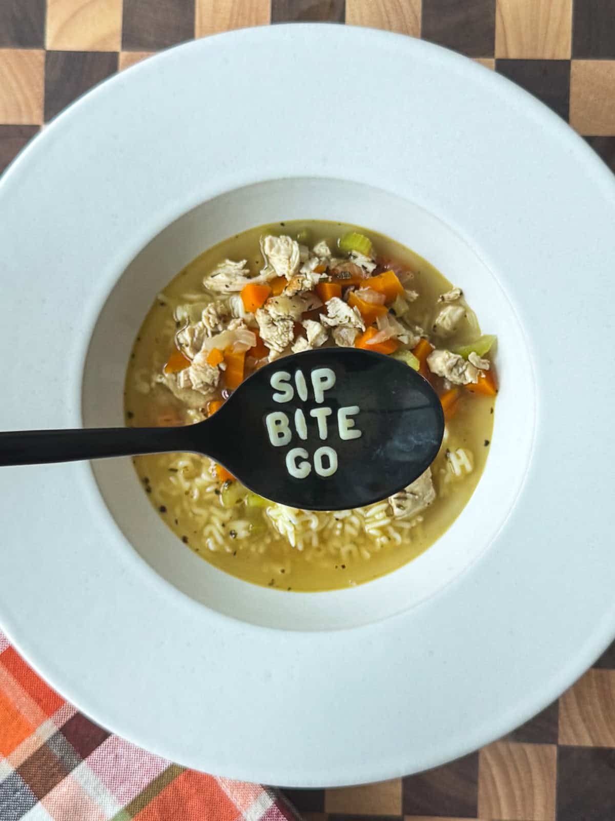 Sip Bite Go alphabet German egg noodles served with homemade chicken noodle soup and fresh veggies