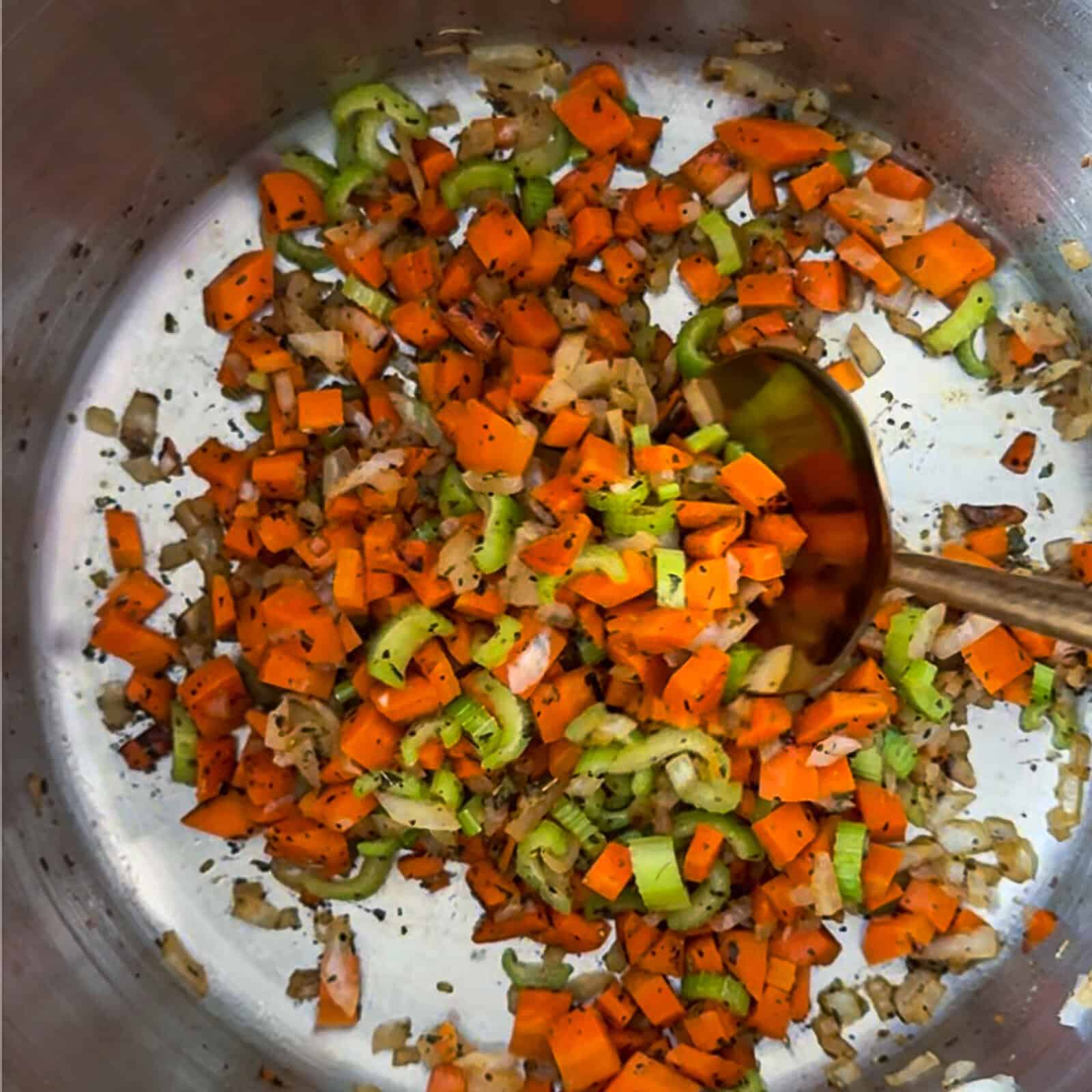 Sautéing diced celery, carrots, and onions in butter for homemade chicken noodle soup