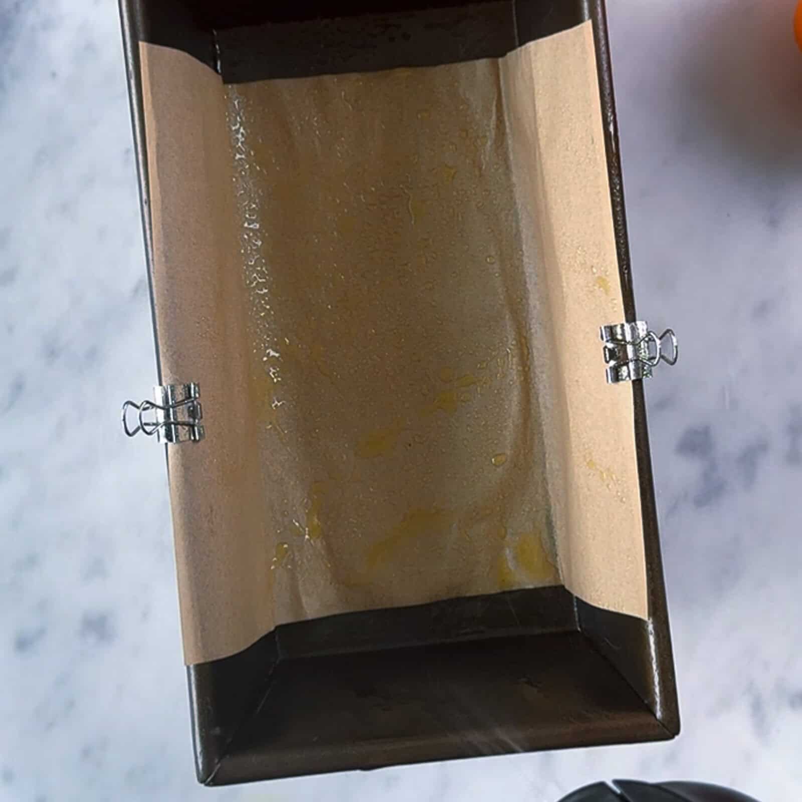 Preparing a loaf pan for chocolate banana bread with parchment paper