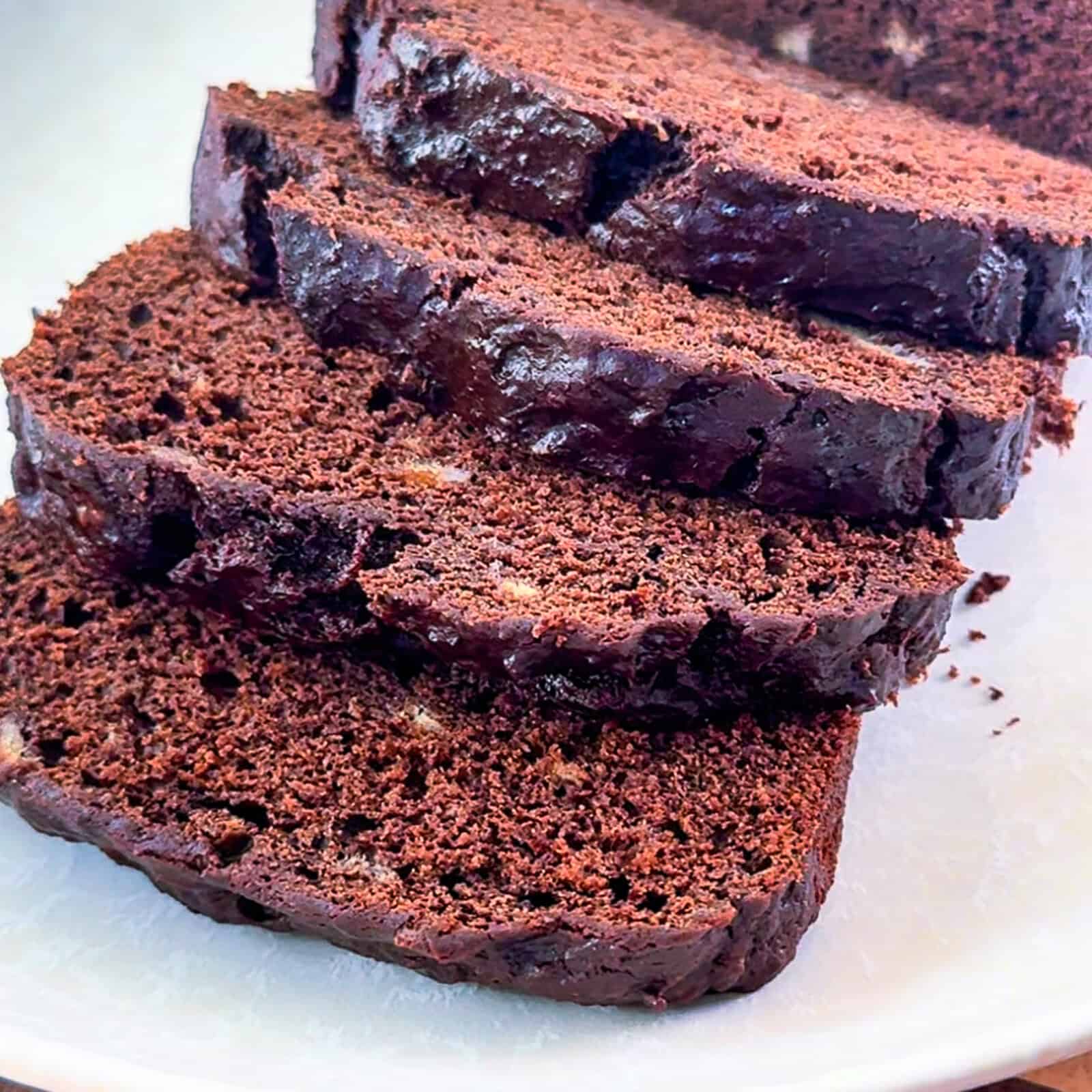 Serving sliced chocolate banana bread loaf on a plate with a knife