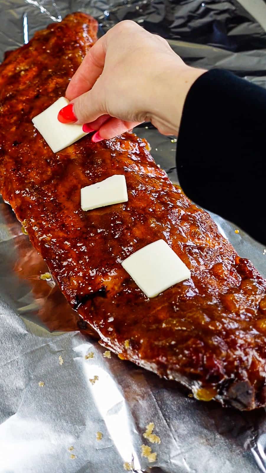 adding butter to ribs