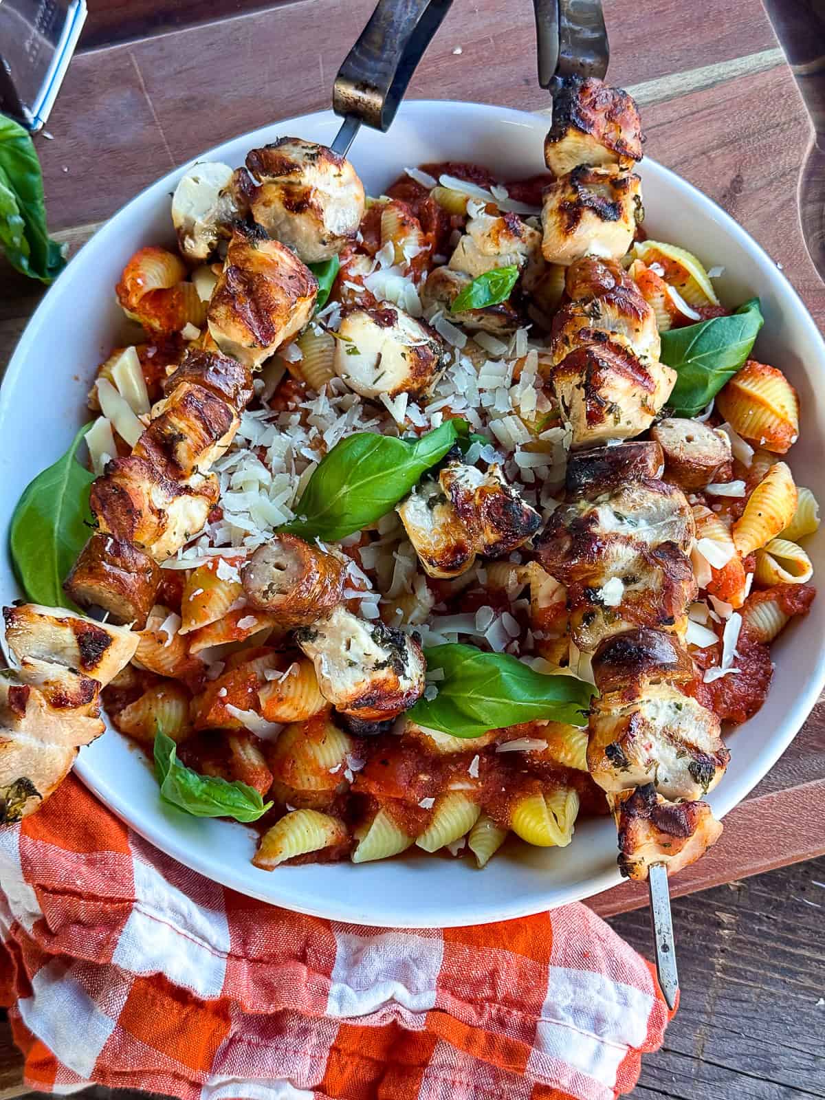 Final plated dish with grilled italian chicken kebabs over pasta