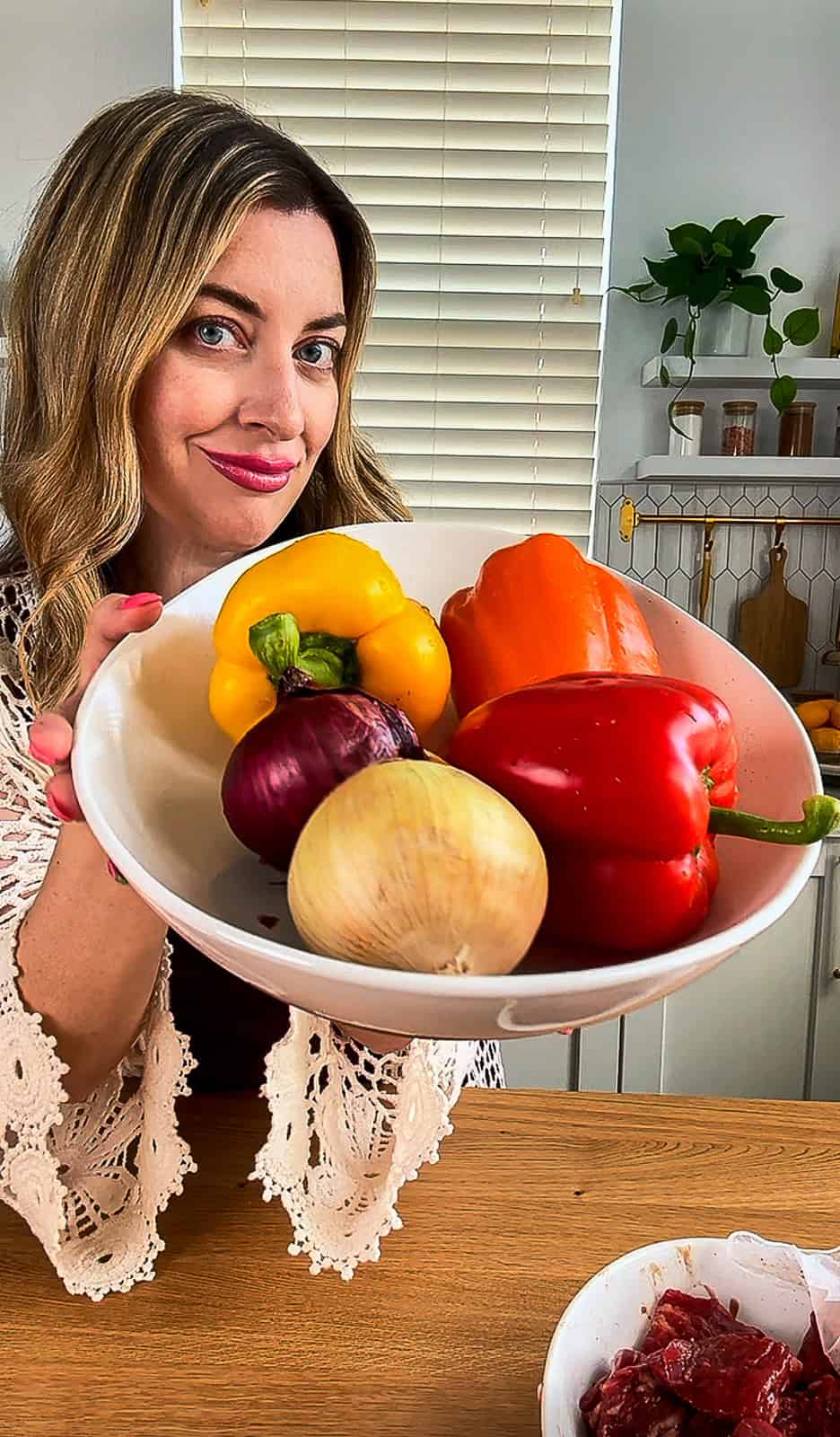 Jenna Passaro holding fresh peppers and onions in bowl