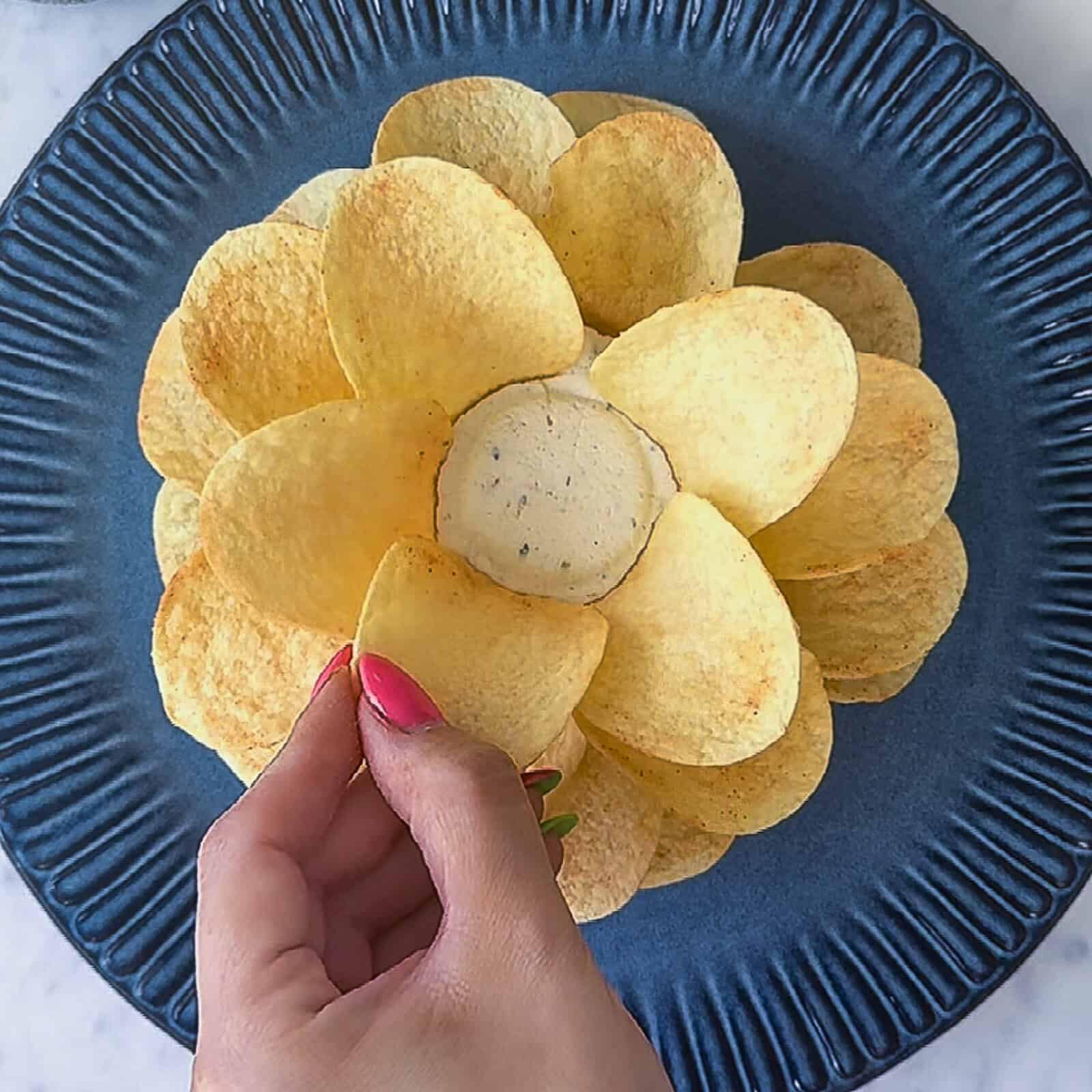 Pringles chips arranged to create a blooming flower effect around cheese