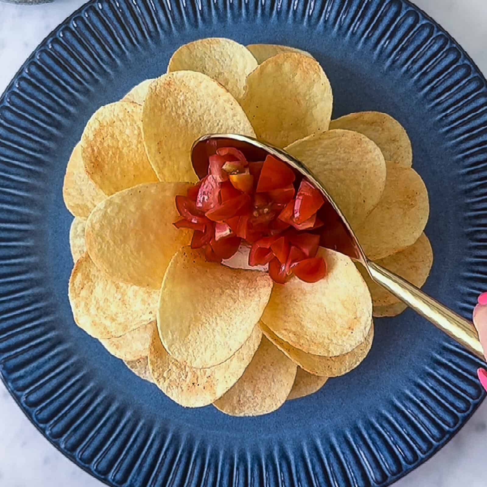 diced cherry tomatoes in the center of a Boursin cheese and Pringles chip flower