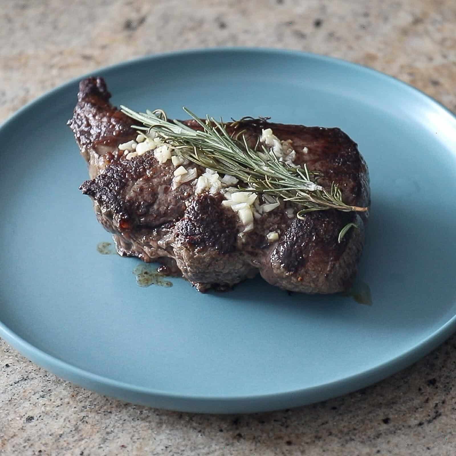 Resting cooked sirloin steak on a cutting board before slicing