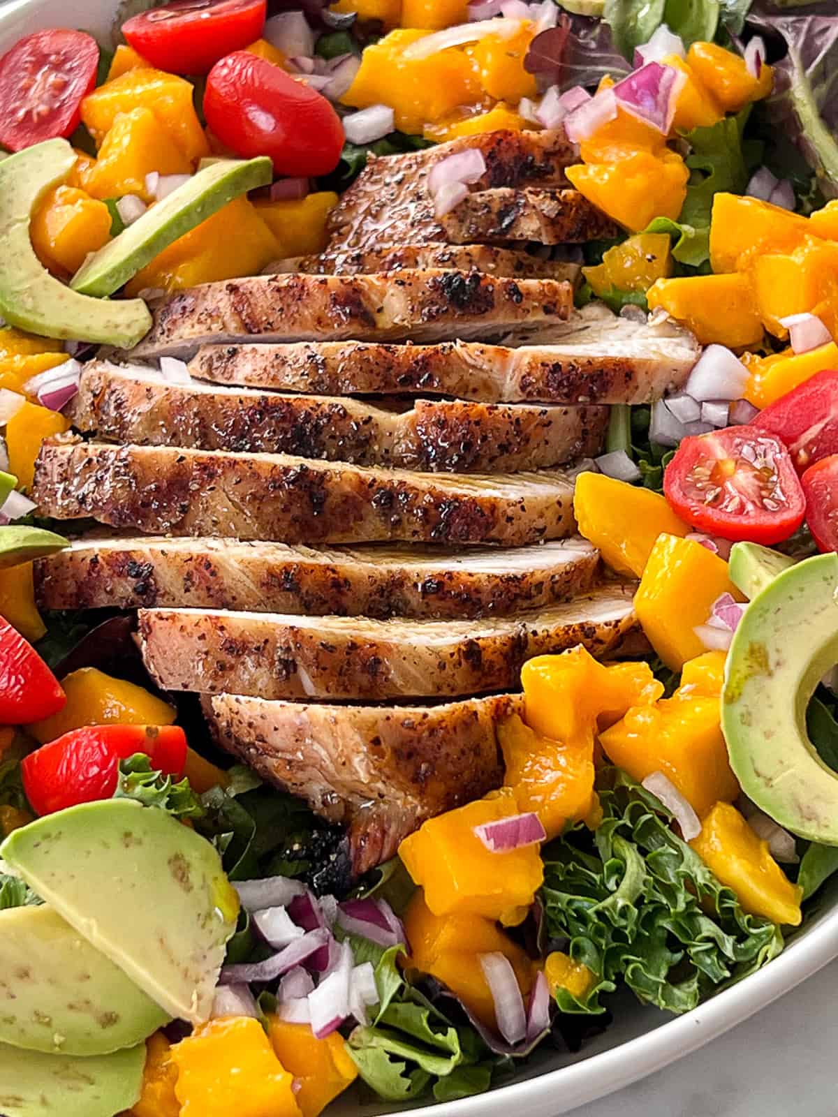 BBQ grilled chicken breast on mango salad summer dinner