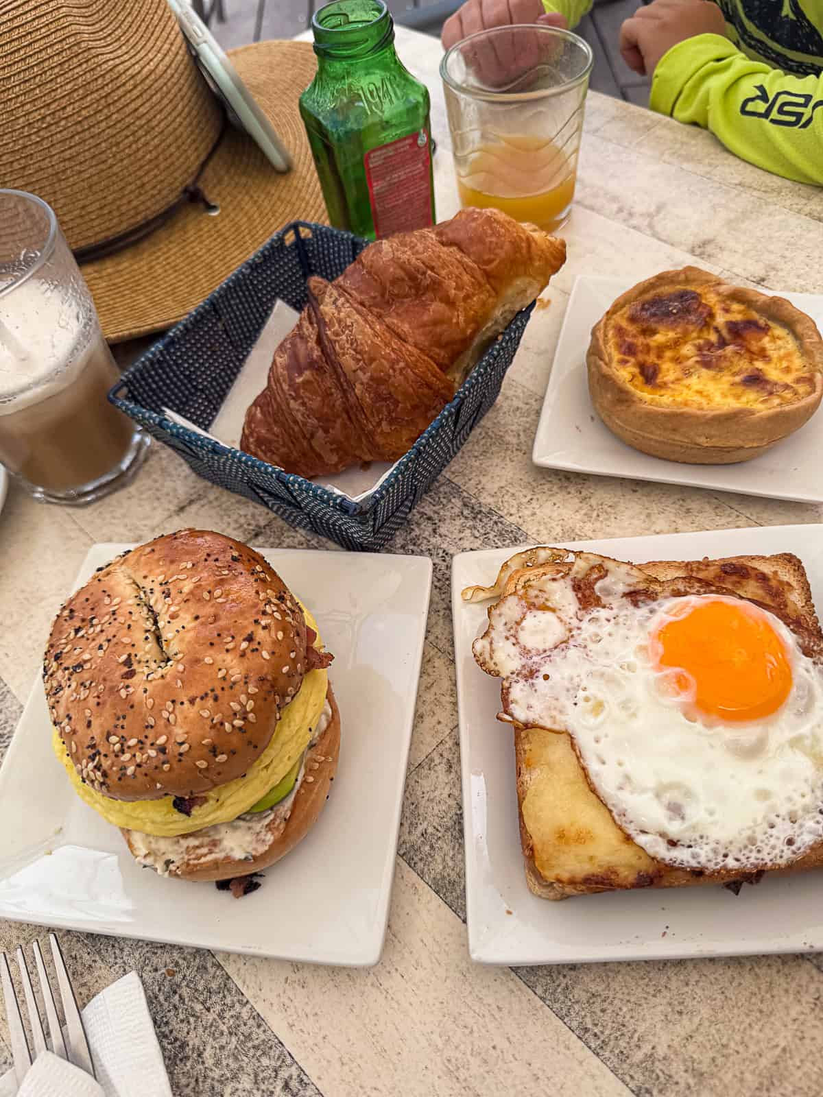 Outdoor café table with croissants, quiche, and iced coffee at Good Morning Café on Orient Beach