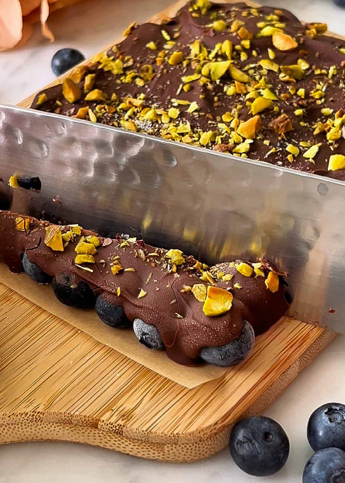 Slicing frozen chocolate covered blueberry bark