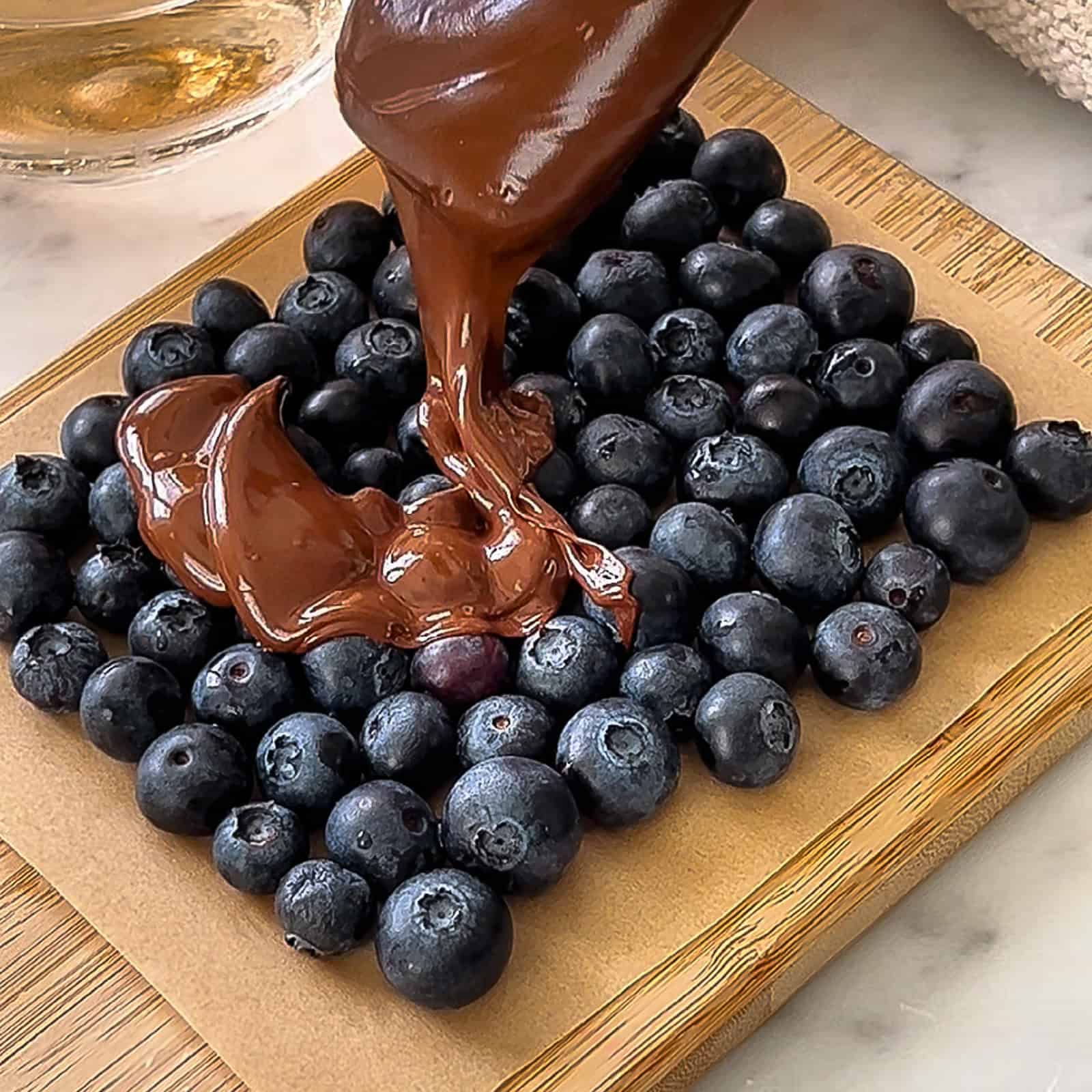 Drizzling melted chocolate over fresh blueberries