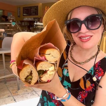 Jenna Passaro posing with fresh baguettes at the entrance of Good Morning Café on Orient Beach in St. Maarten