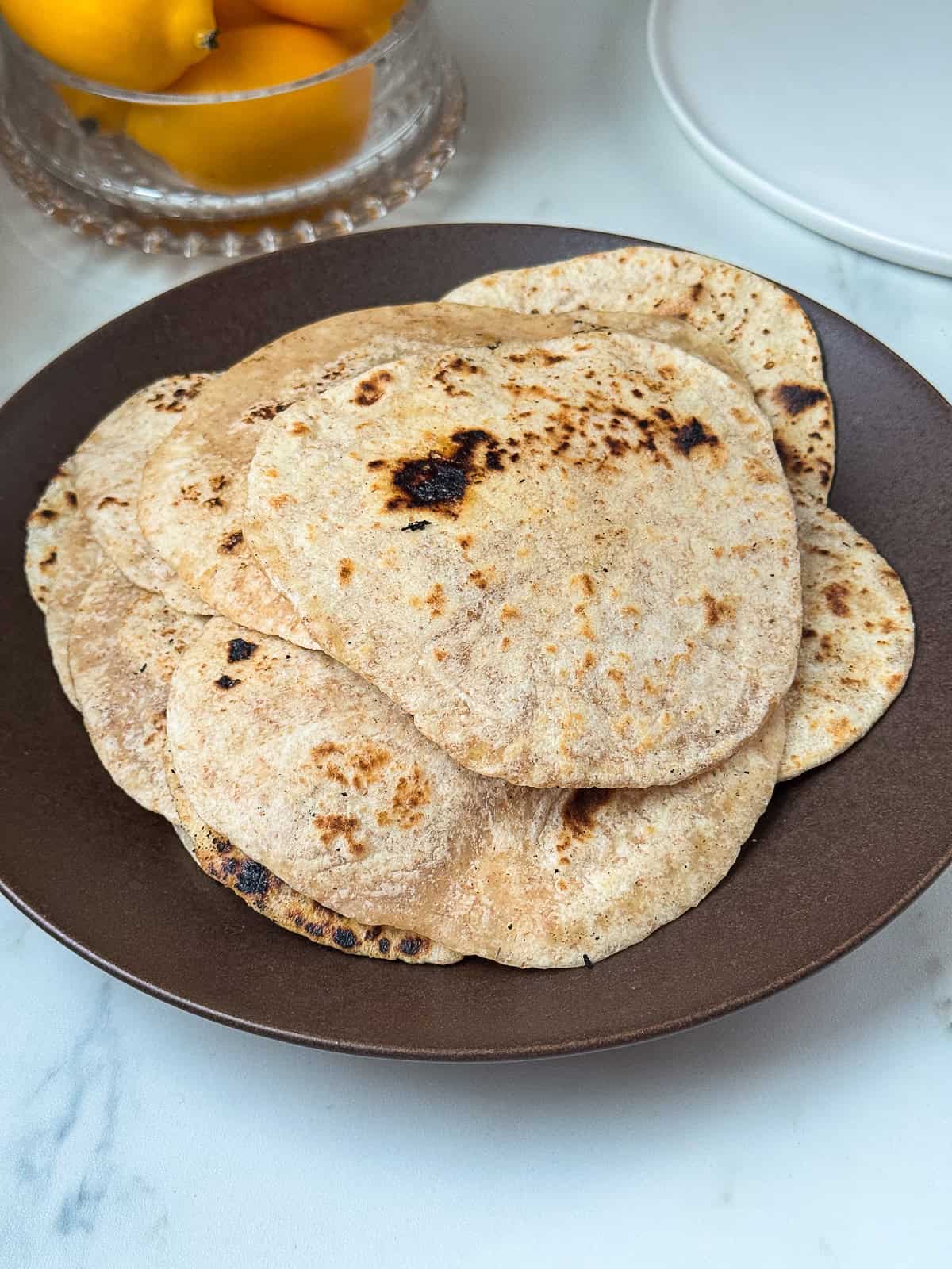 stack of warm butter tortillas served on a plate