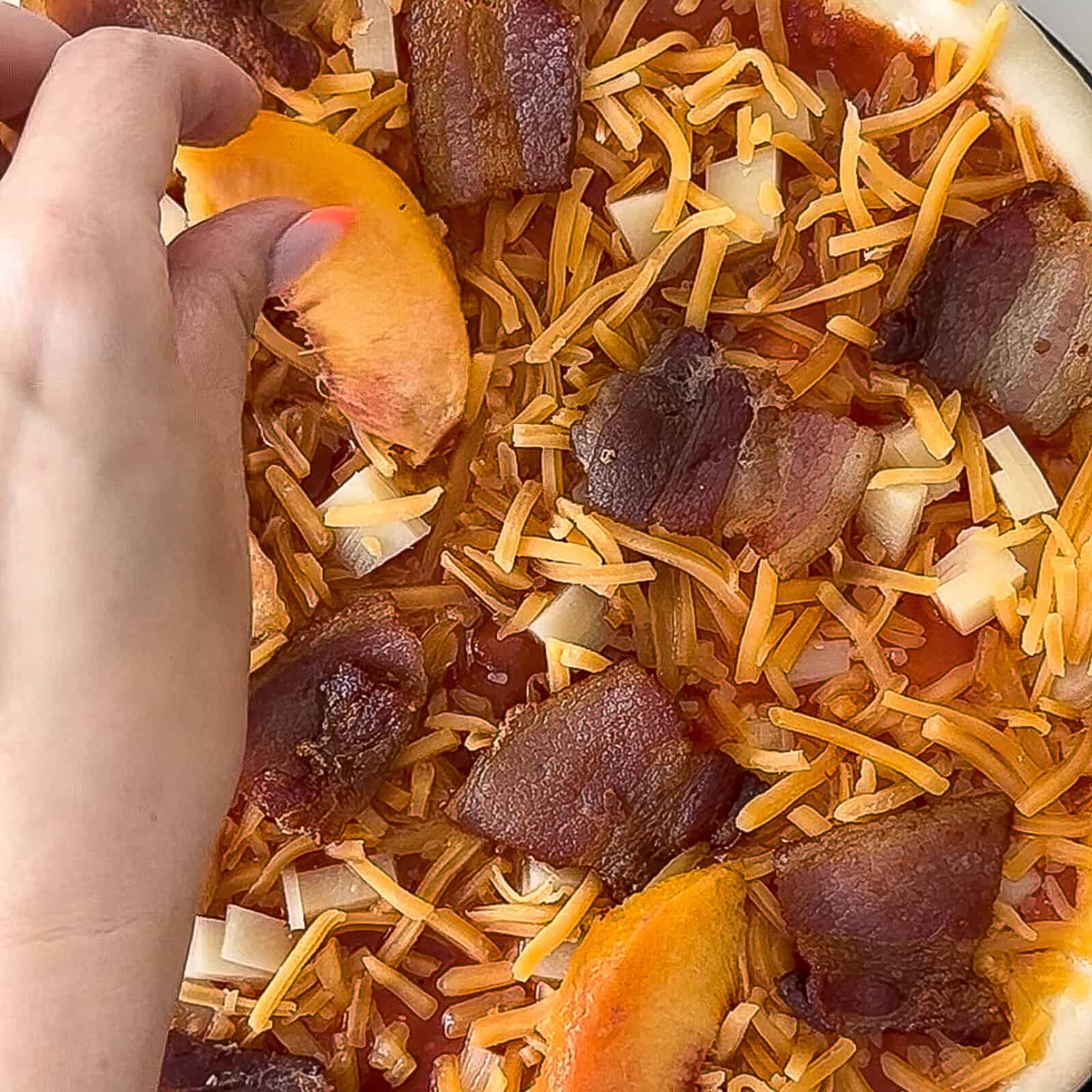 Assembling peach and bacon pizza with toppings