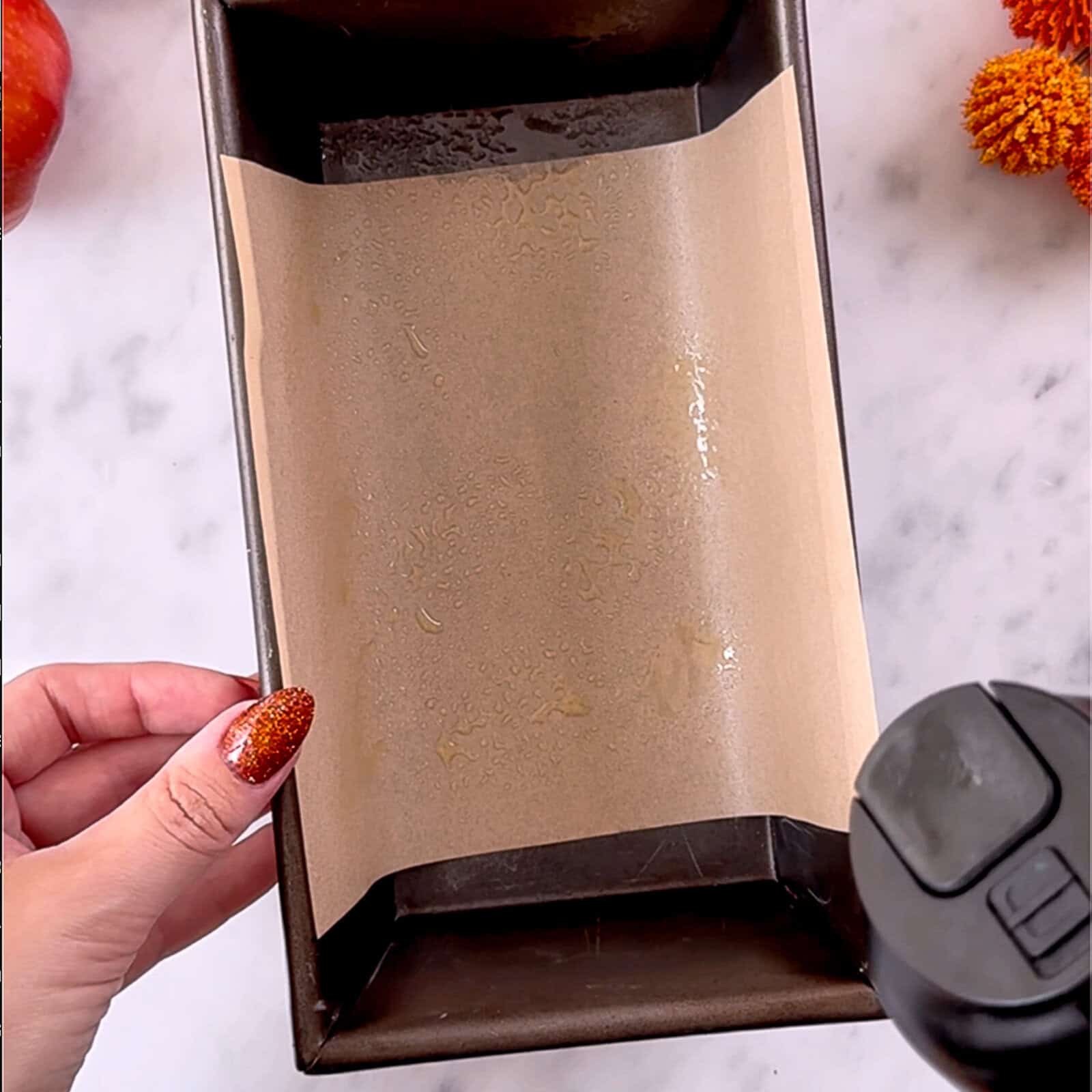 lining a loaf pan with parchment paper for banana bread