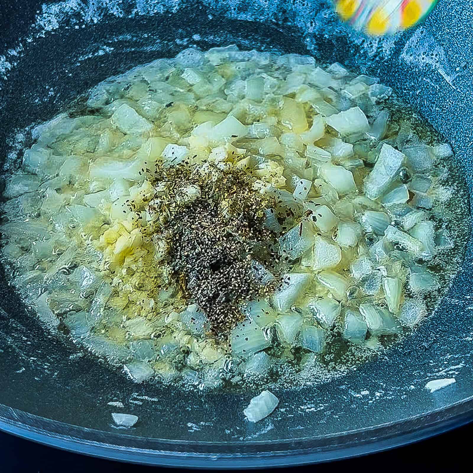 Melting butter with chopped onion and seasonings in a pan