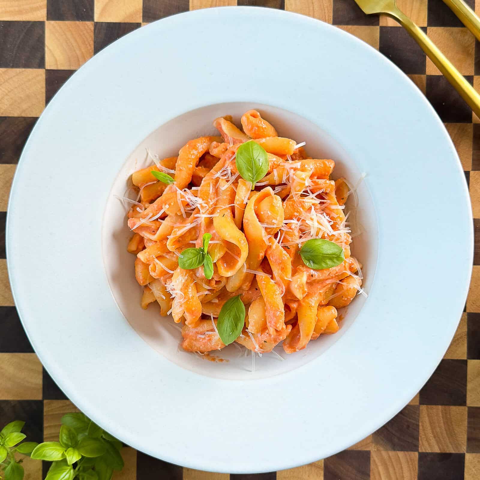 Plated creamy tomato mozzarella pasta dish ready to serve
