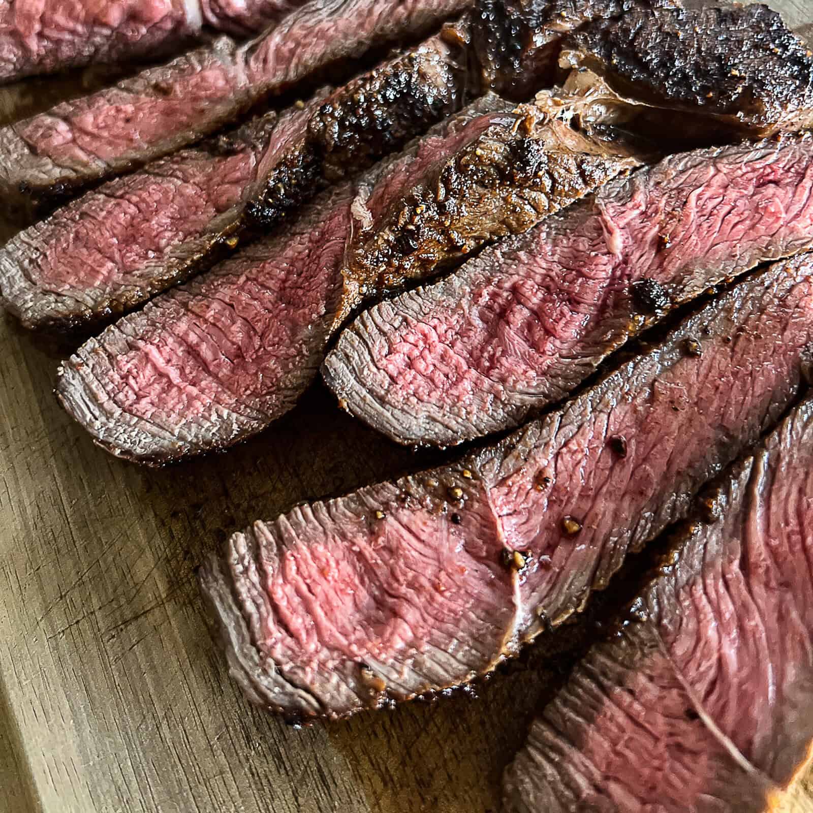 Medium-cooked sirloin steak resting on a cutting board