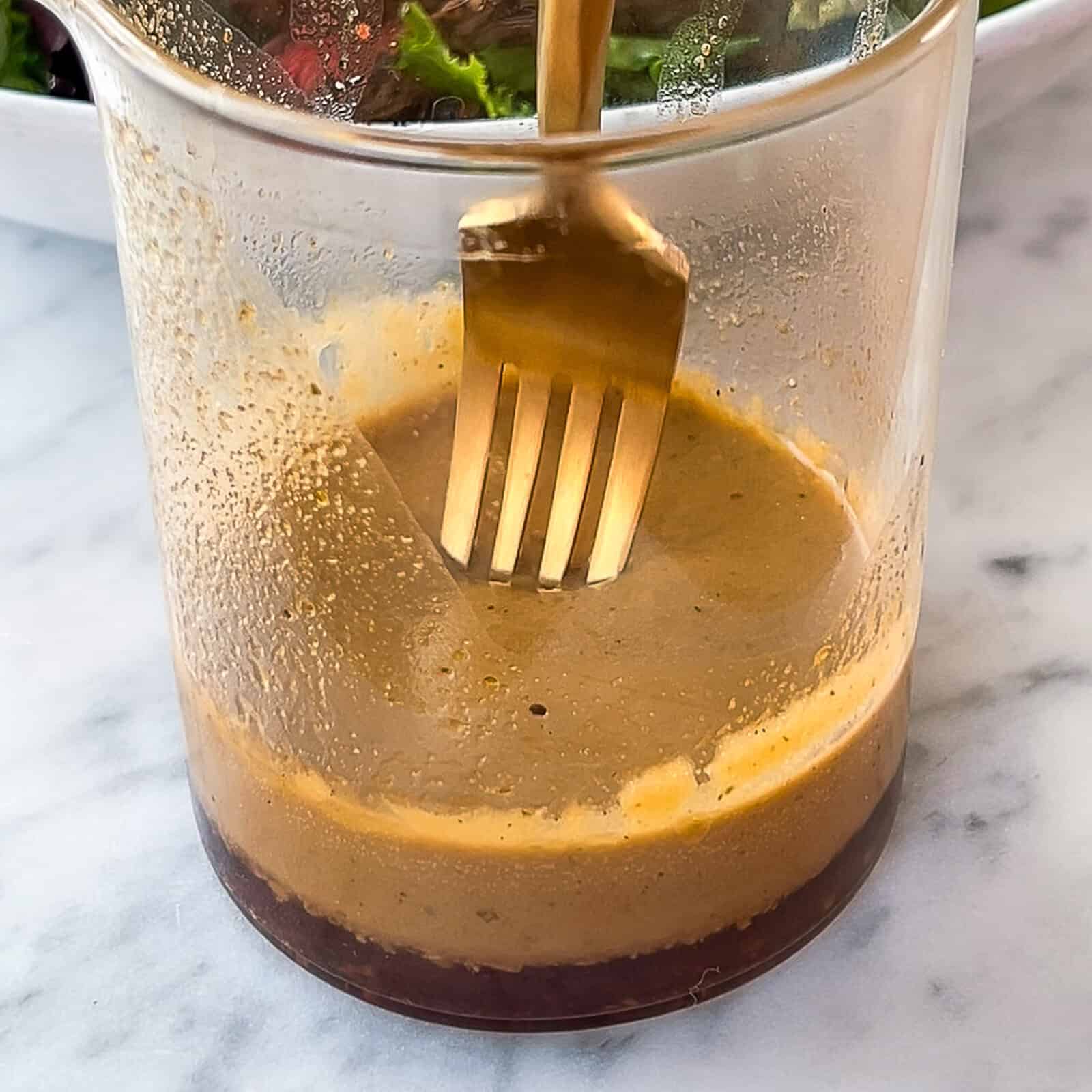 Adding mango and other toppings on top of steak salad