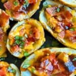 Loaded BBQ chicken potato skins with bacon on a plate, text overlay