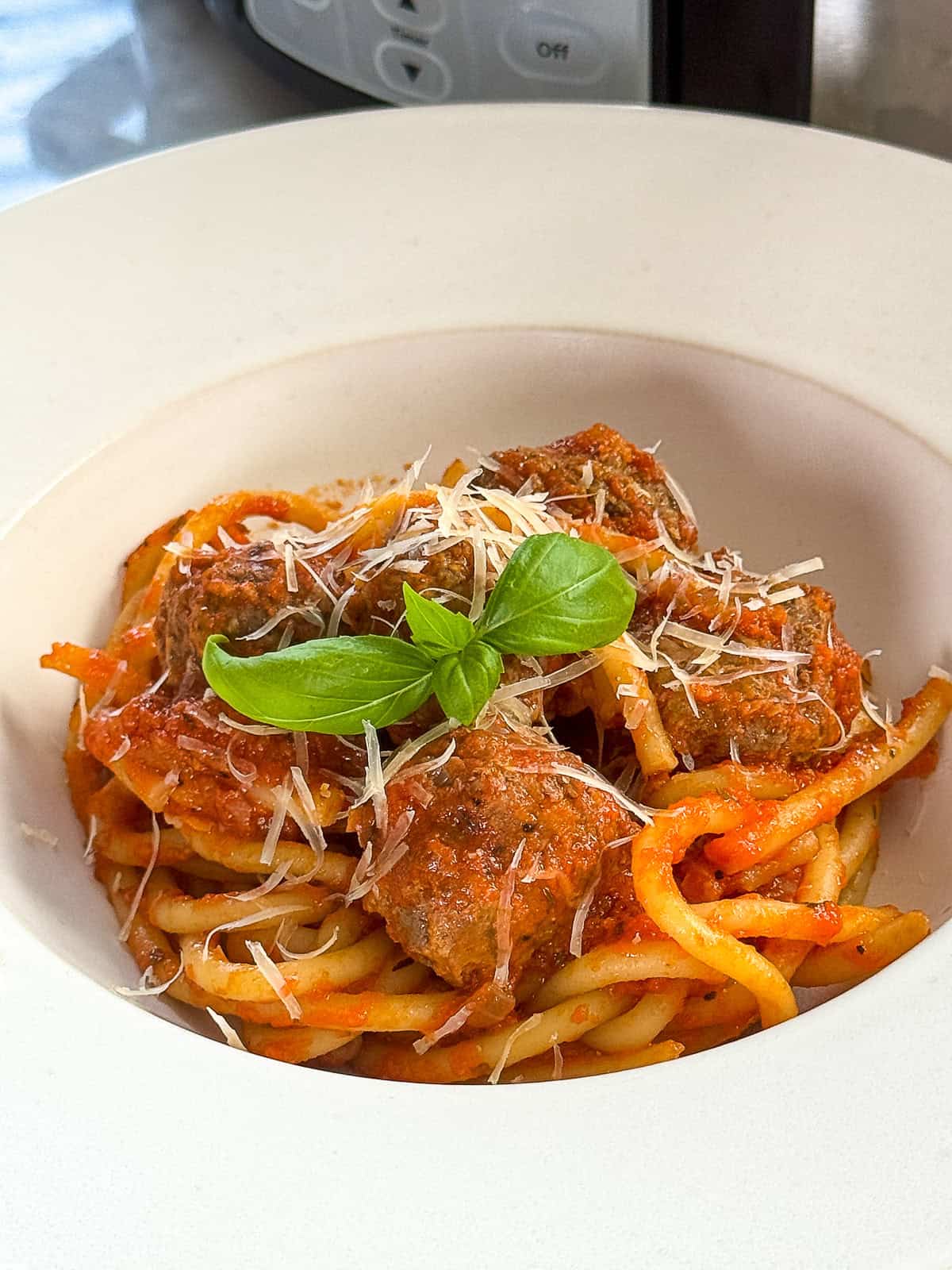 Serving slow cooked meatballs in a bowl with pasta for an Italian dinner
