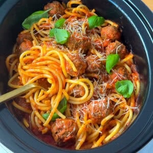 Spaghetti and meatballs cooking together in a crock pot slow cooker recipe