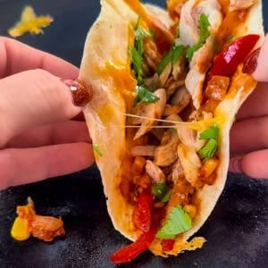 the best chicken tacos recipe loaded with peppers, onions, and corn on a plate