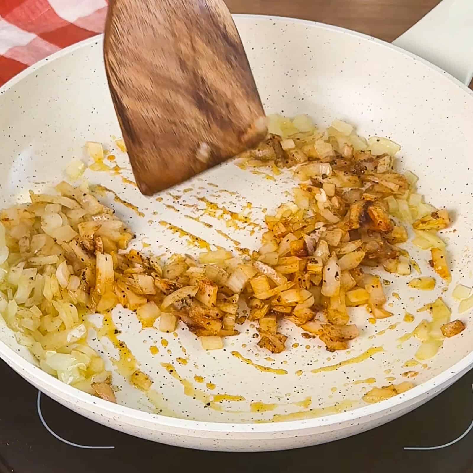 Cooking diced onion in a skillet for viral nachos