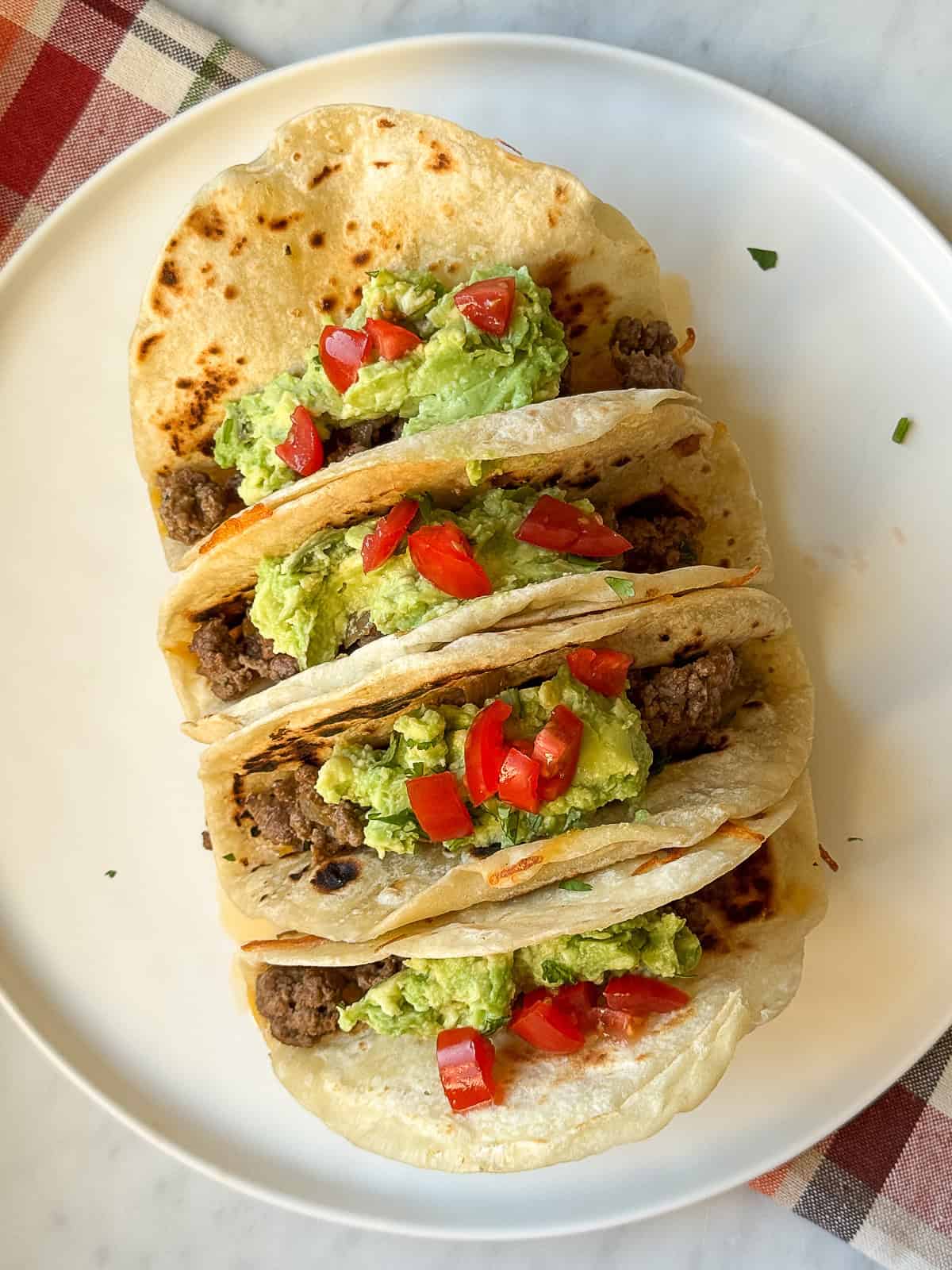 Salsa Verde Ground Beef Tacos served in crispy cheese tortilla shells on a plate