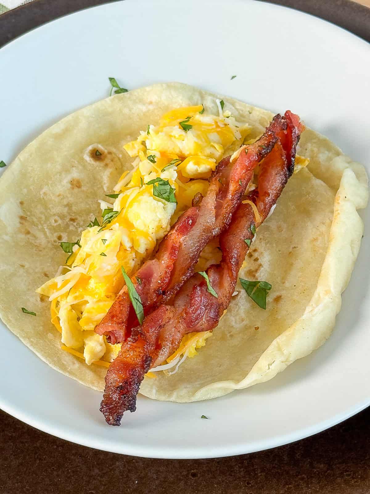 Scrambled egg taco topped with crispy BBQ twisted bacon cooked in the oven