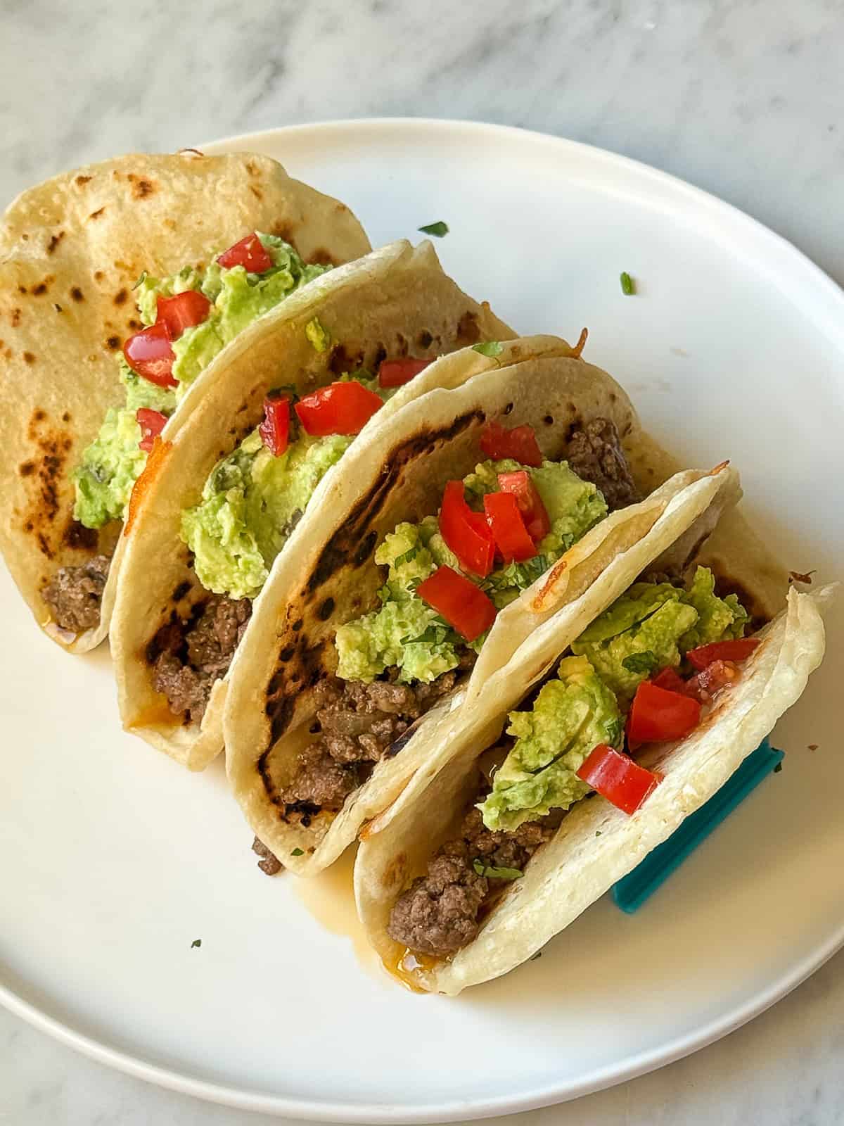 Taco Night dinner with Salsa Verde Ground Beef filling, avocado, and tomatoes