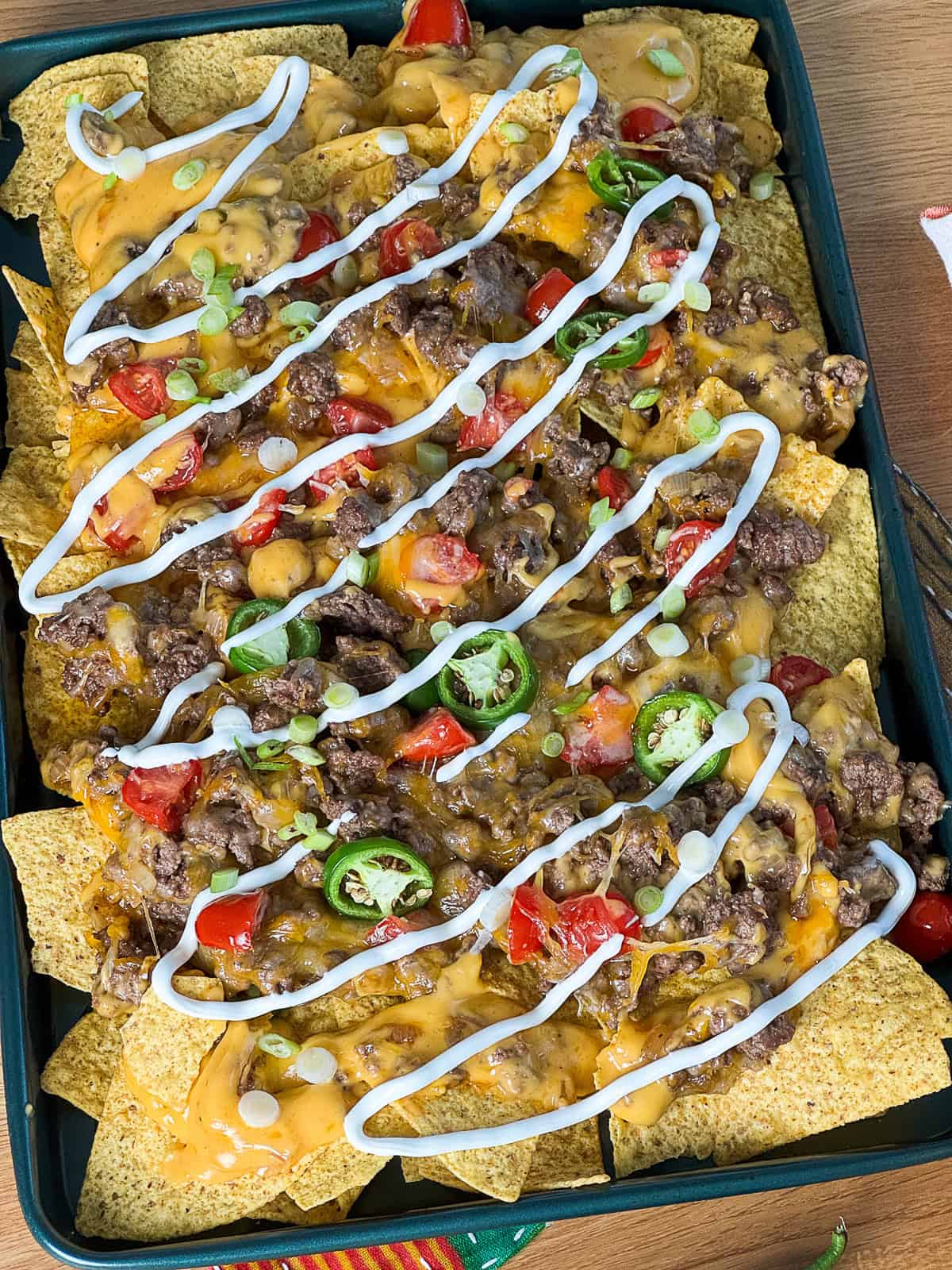Top-down view of viral sheet pan nachos with sliding cheese and ground beef
