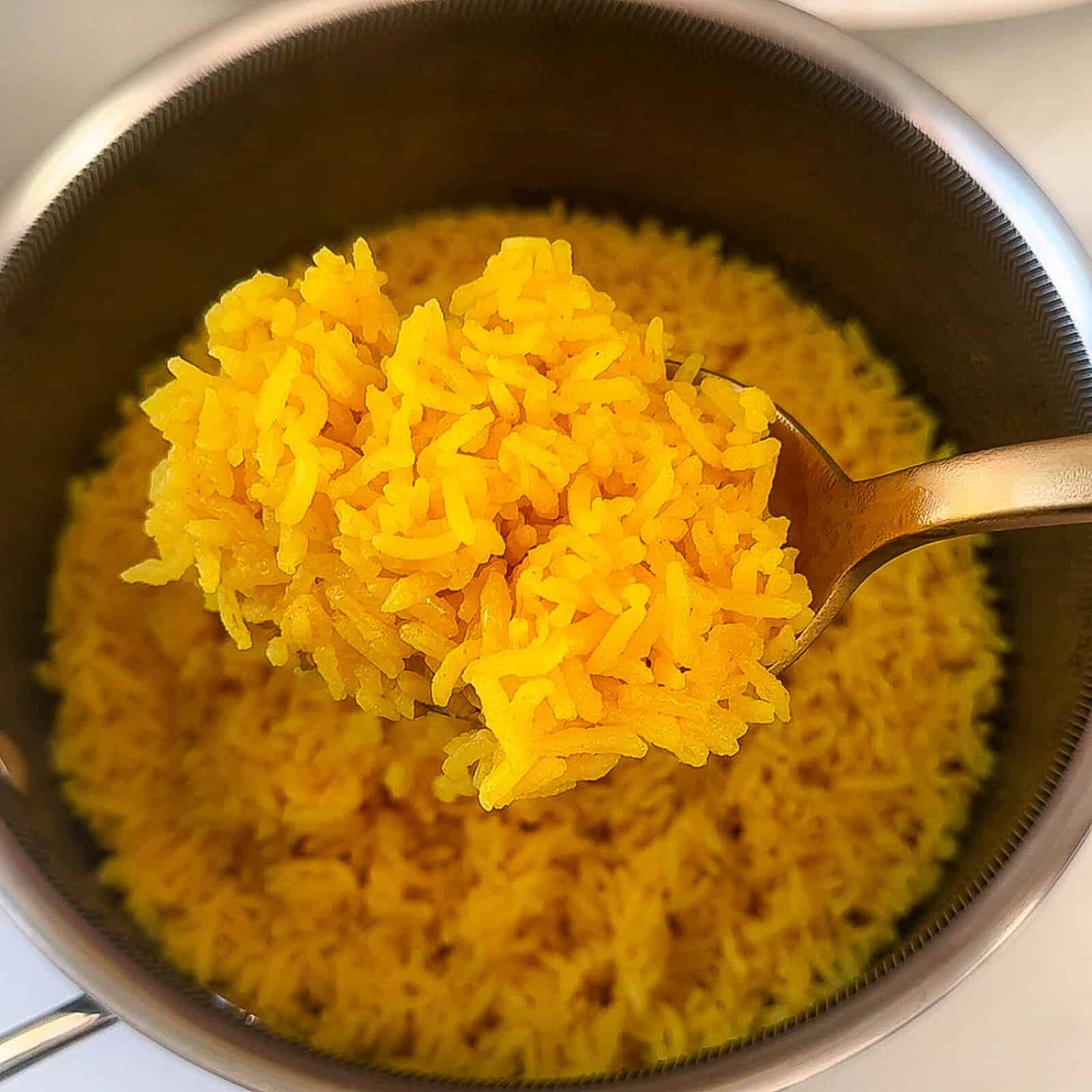 Turmeric rice cooking in a pot on the stove