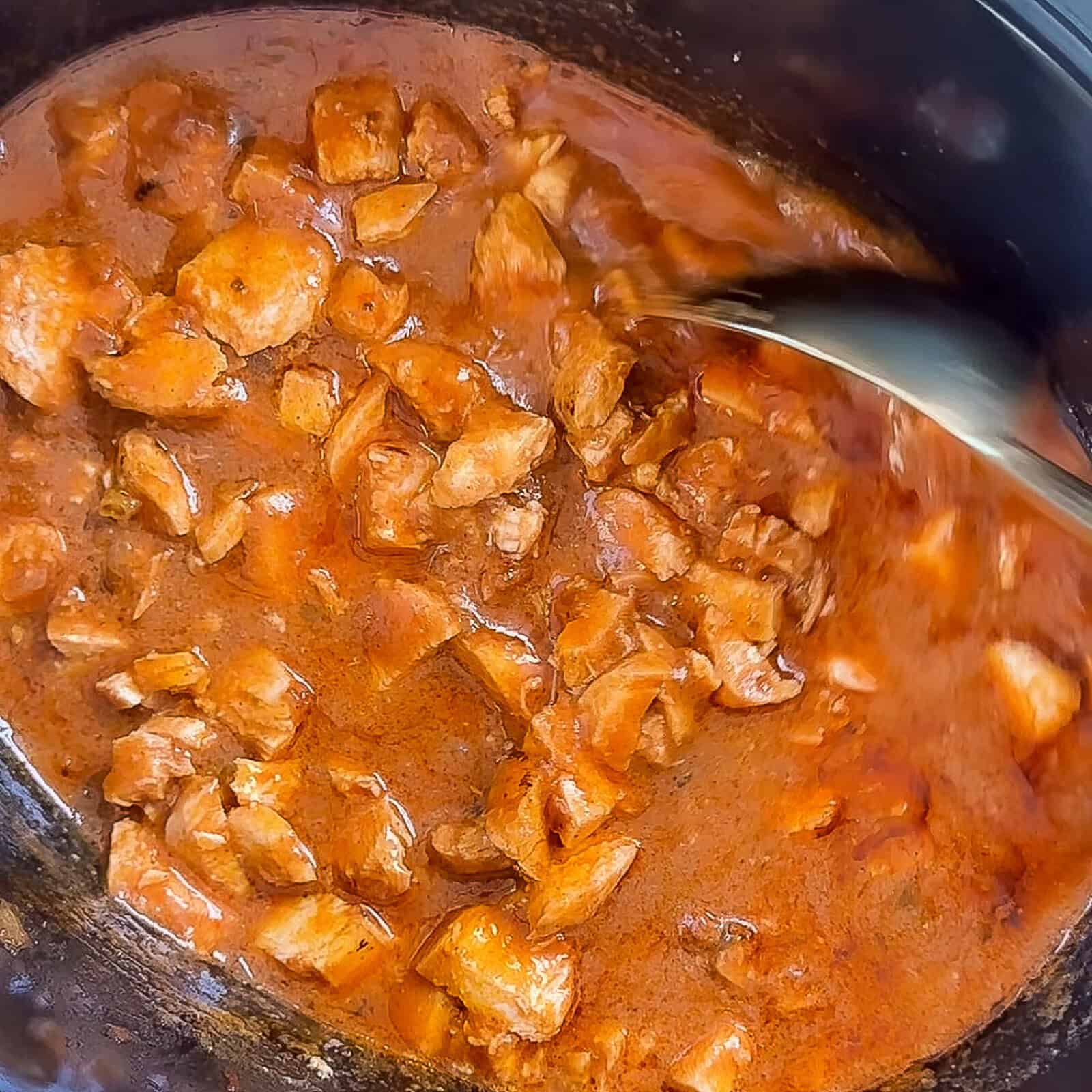 Slow-cooked diced chicken breast in butter masala sauce inside crockpot