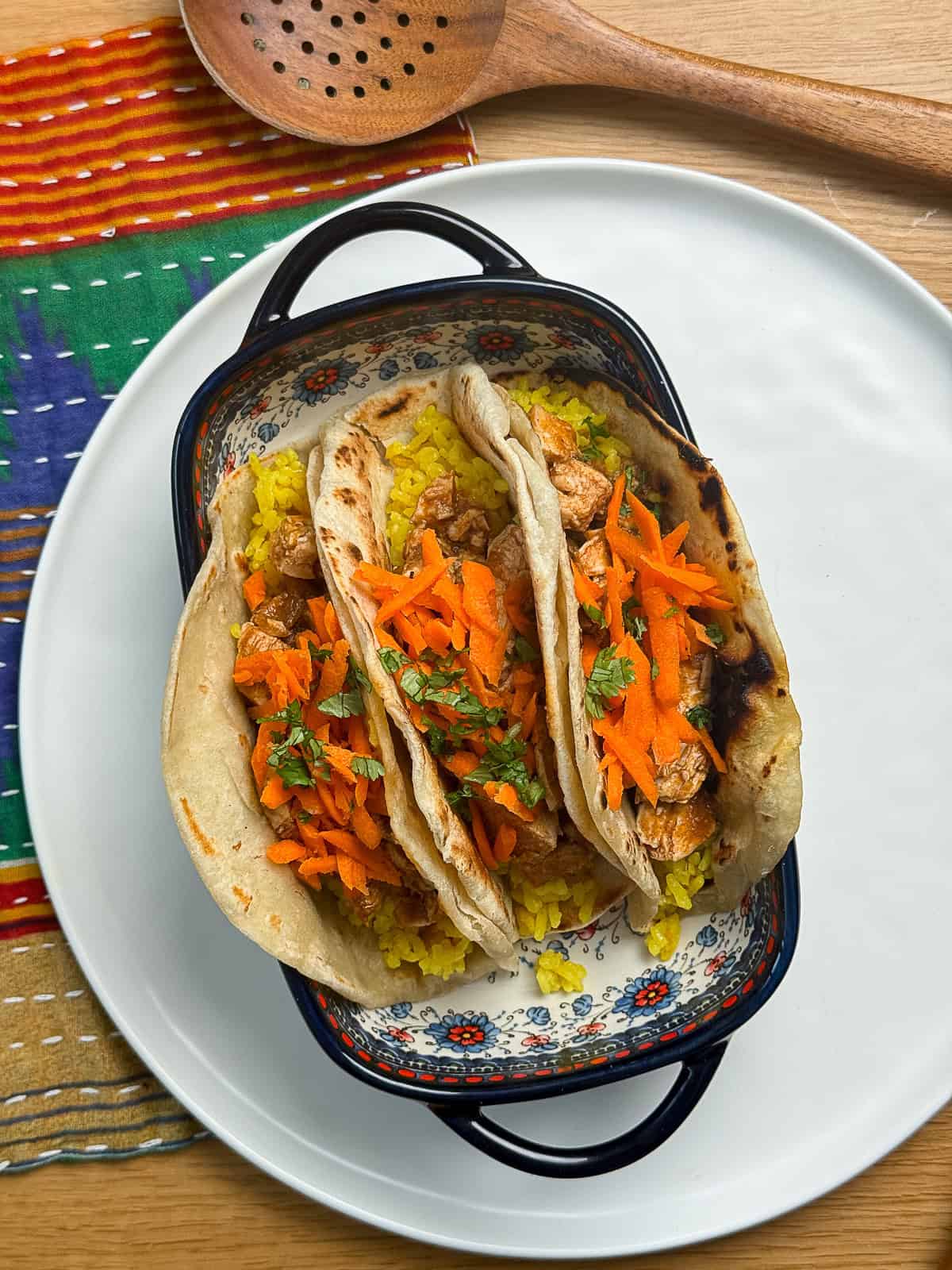 Butter chicken tacos with turmeric rice served on a dinner plate