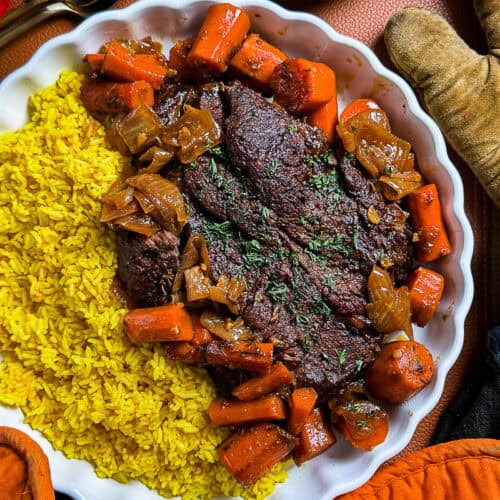 Oven-roasted pot roast in enchilada sauce served with carrots and rice