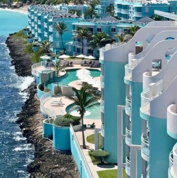 Pool and beach view at Oyster Bay Beach Resort with clear water, lounge chairs, and ocean in background