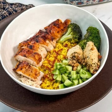 Chicken bowls filled with golden turmeric rice and roasted broccoli, ready to serve