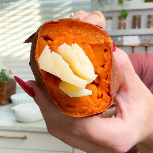 Close-up of a sweet potato stuffed with melted cheese and butter inside