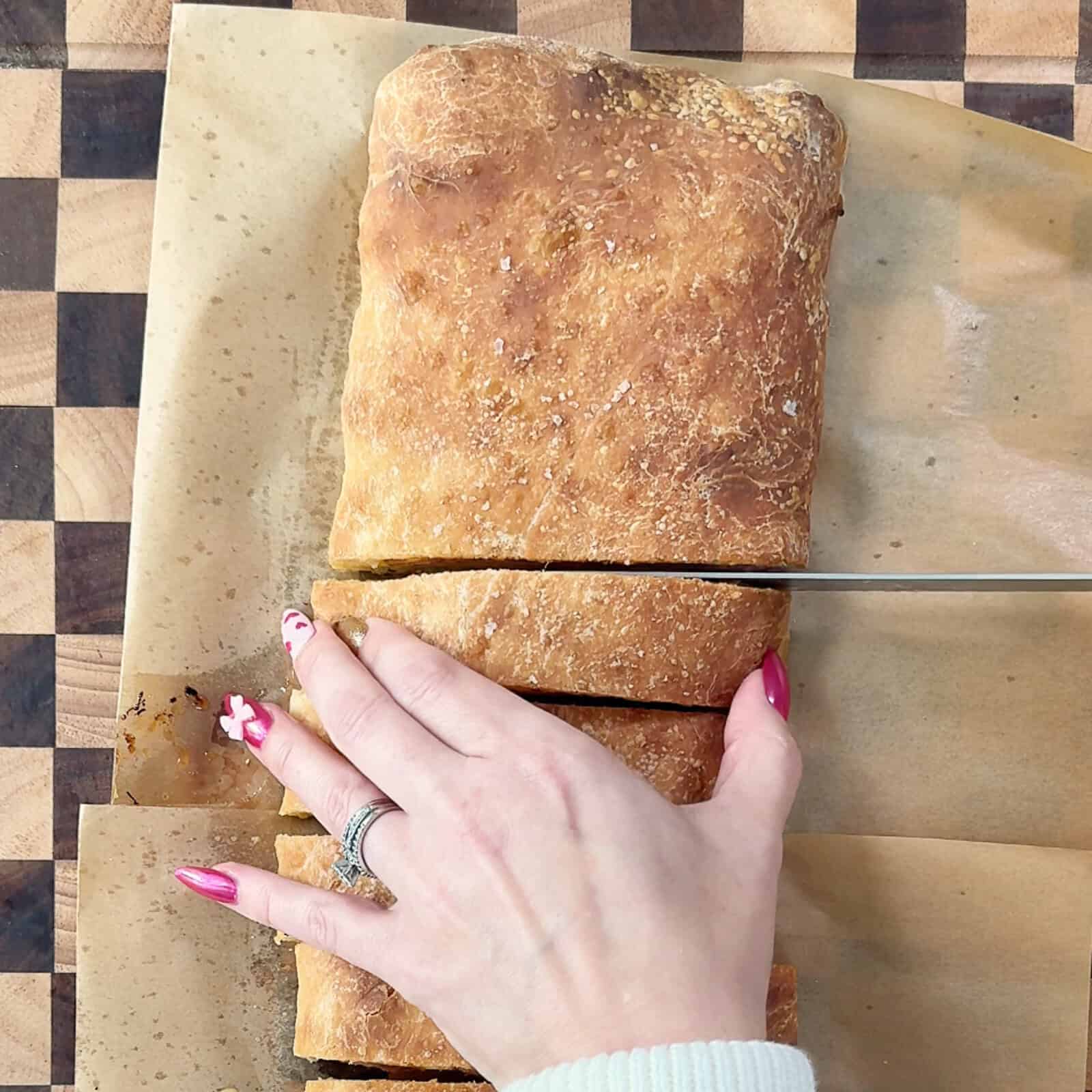 Close-up of a ham and cheese stromboli being sliced, showing melted cheese and layers of ham inside