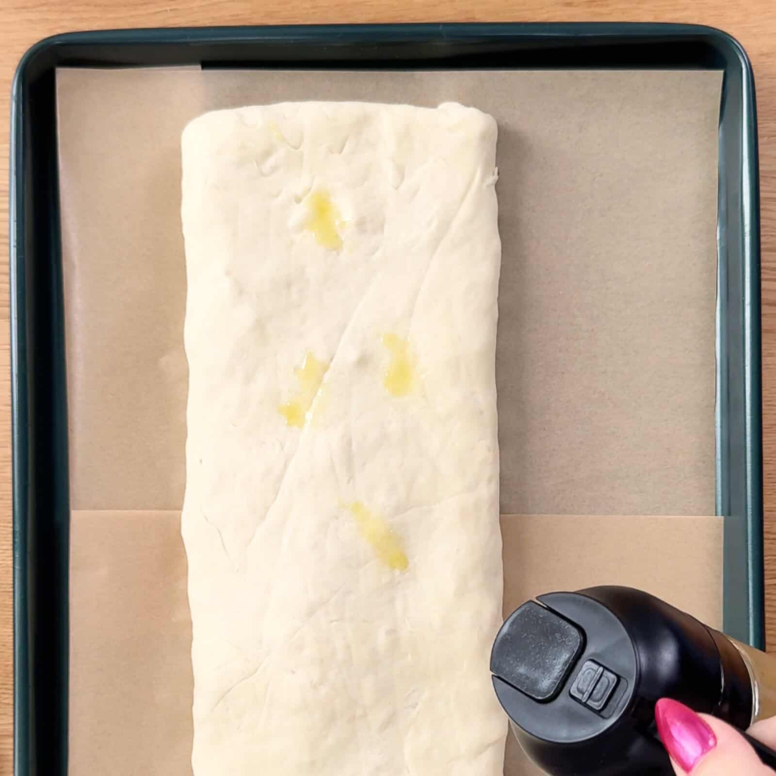 Stromboli placed on a parchment-lined baking sheet ready for the oven